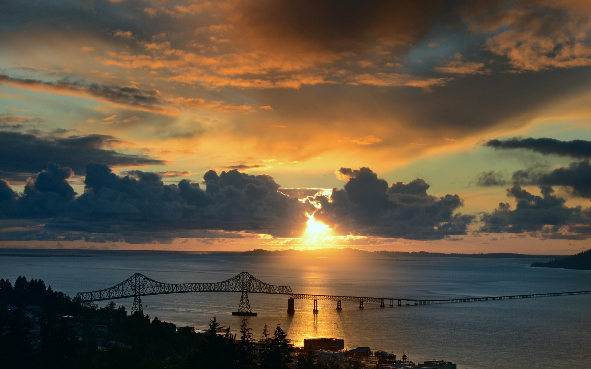 Bridge over water at sunset with dramatic clouds HD Wallpaper