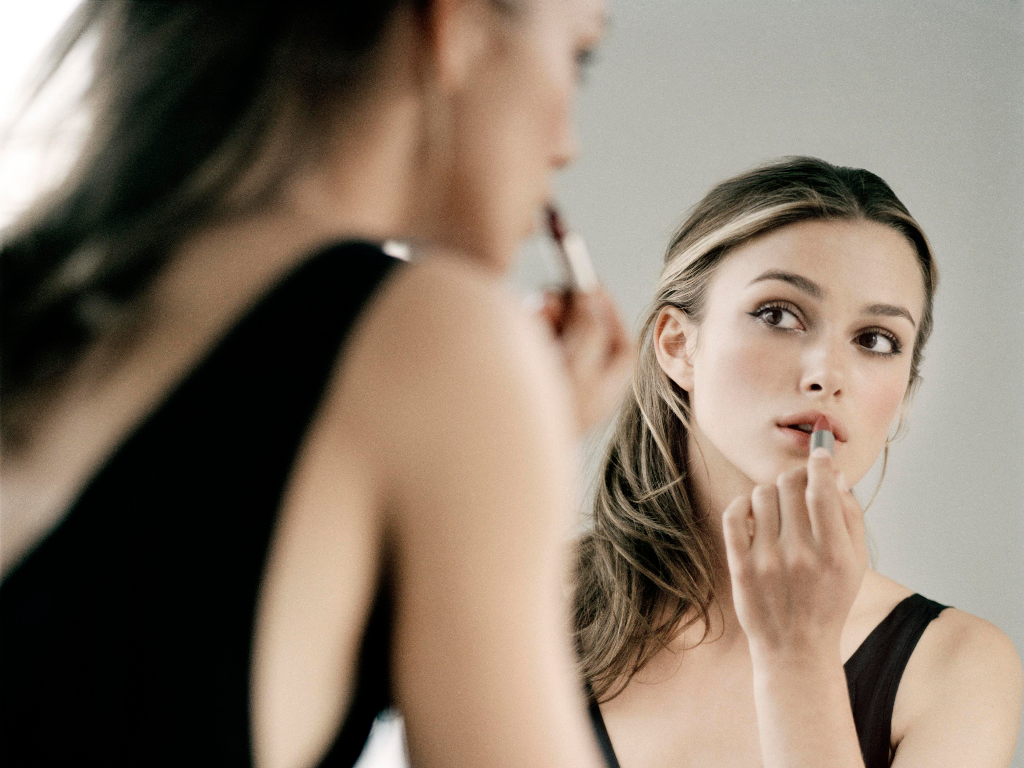 Keira Knightley applying lipstick in mirror HD Wallpaper