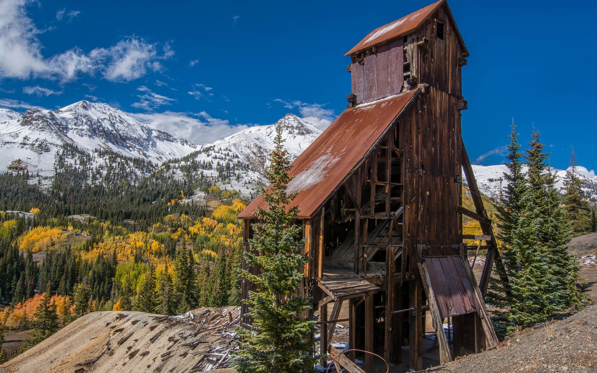 Abandoned wooden mine building with snowy mountains HD Wallpaper