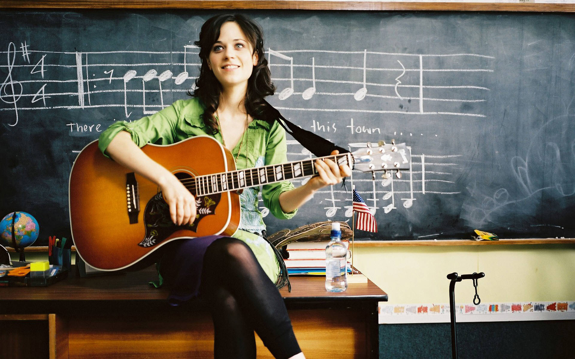 Zooey Deschanel playing guitar in a classroom HD Wallpaper