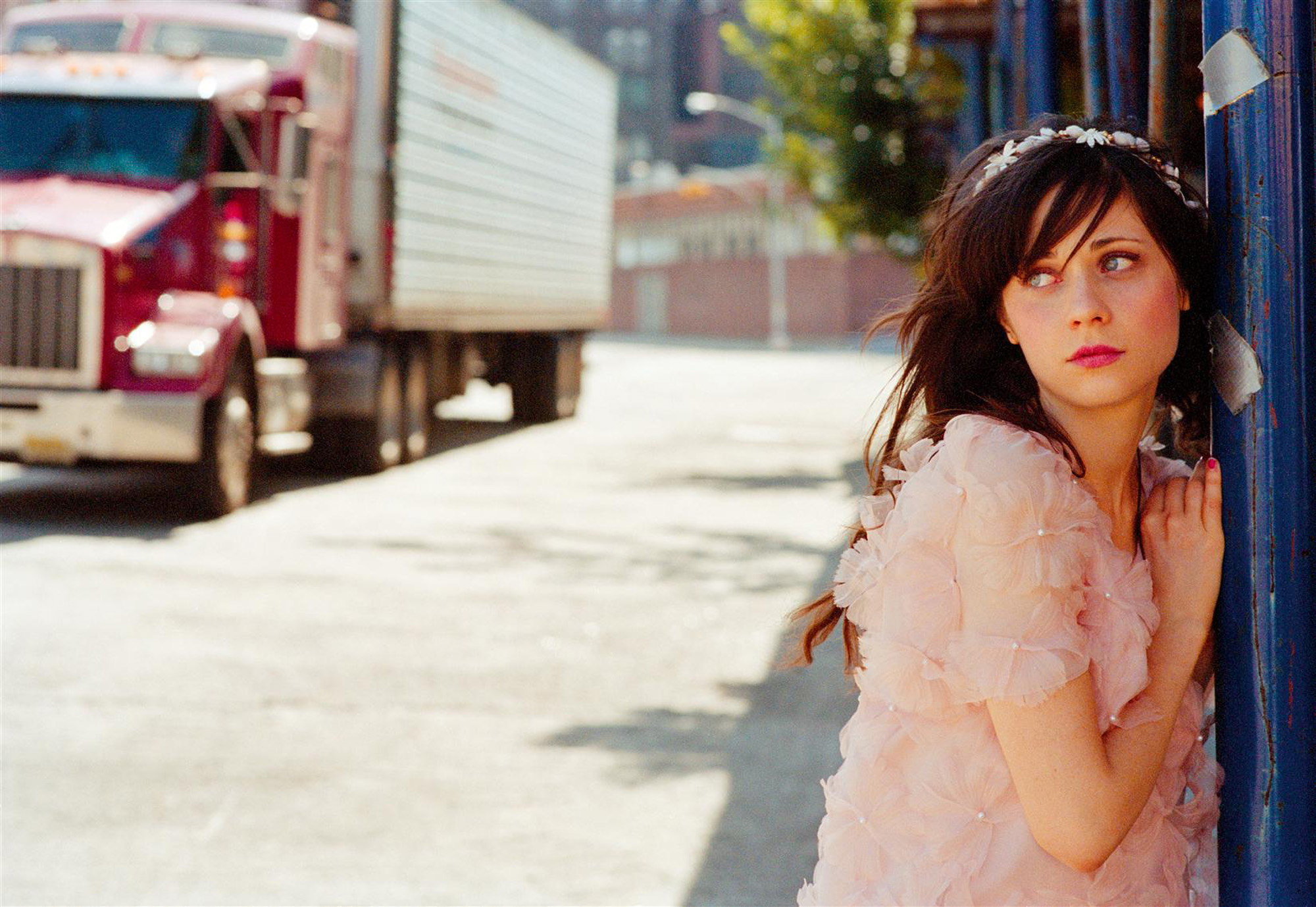Zooey Deschanel leaning against a blue pole HD Wallpaper