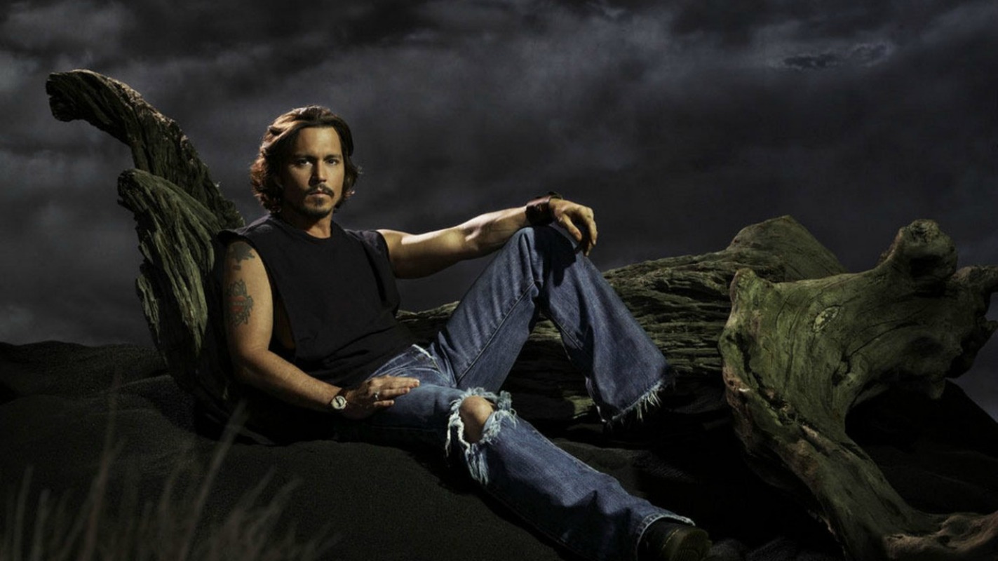 Johnny Depp sitting on driftwood HD Wallpaper
