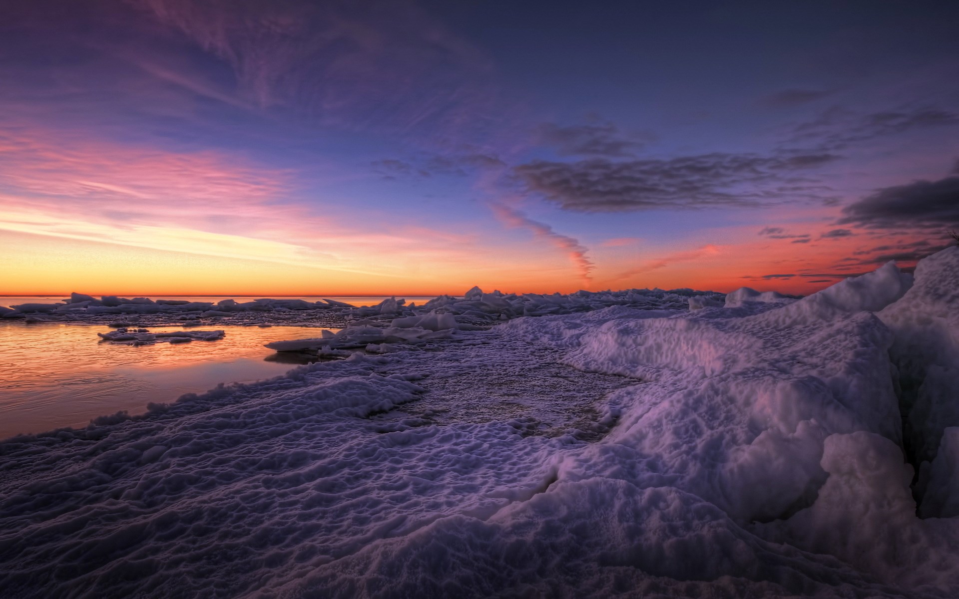 Ice formations on a frozen lake at sunset HD Wallpaper