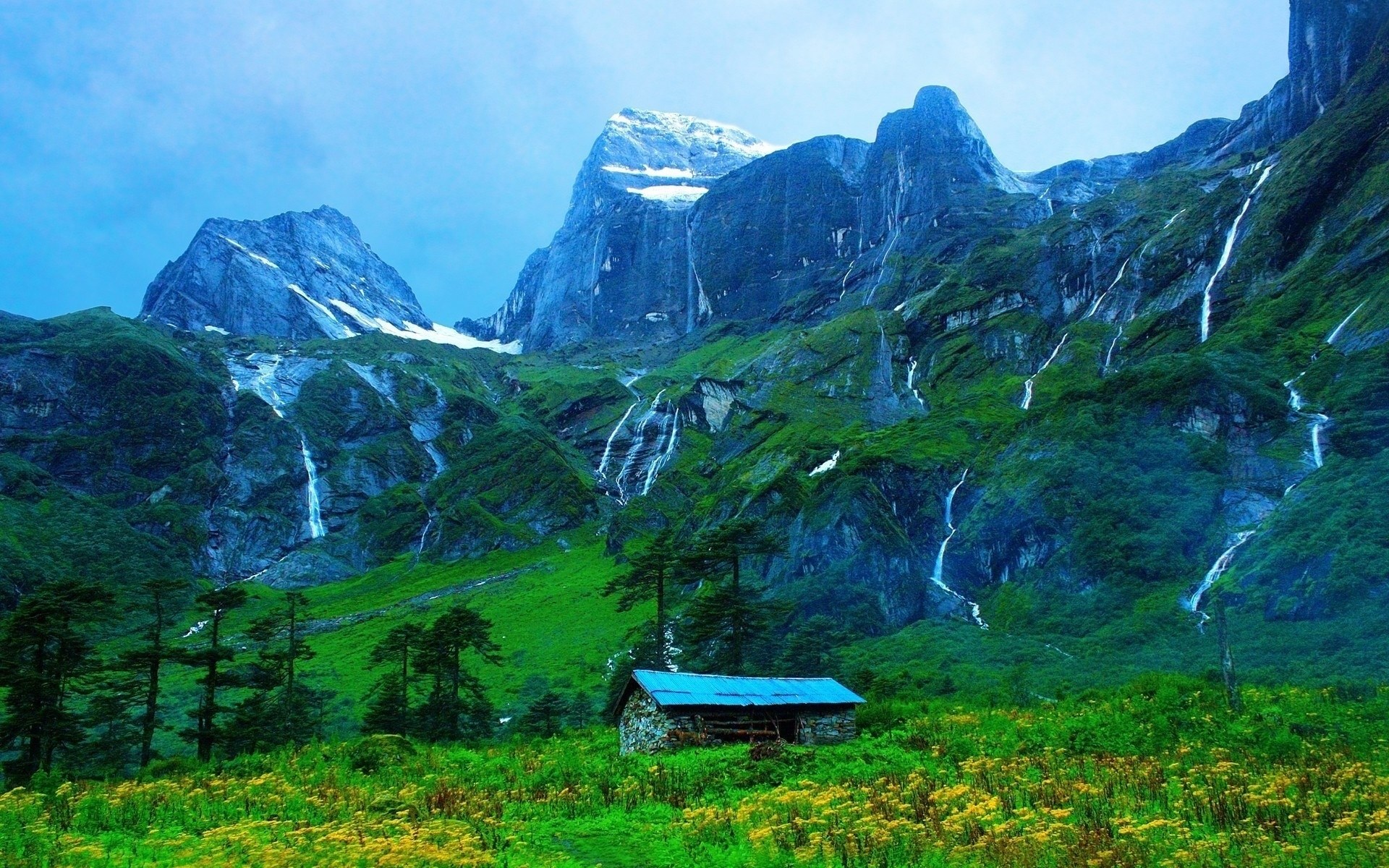 Stone cabin in a green valley with waterfalls and mountains HD Wallpaper