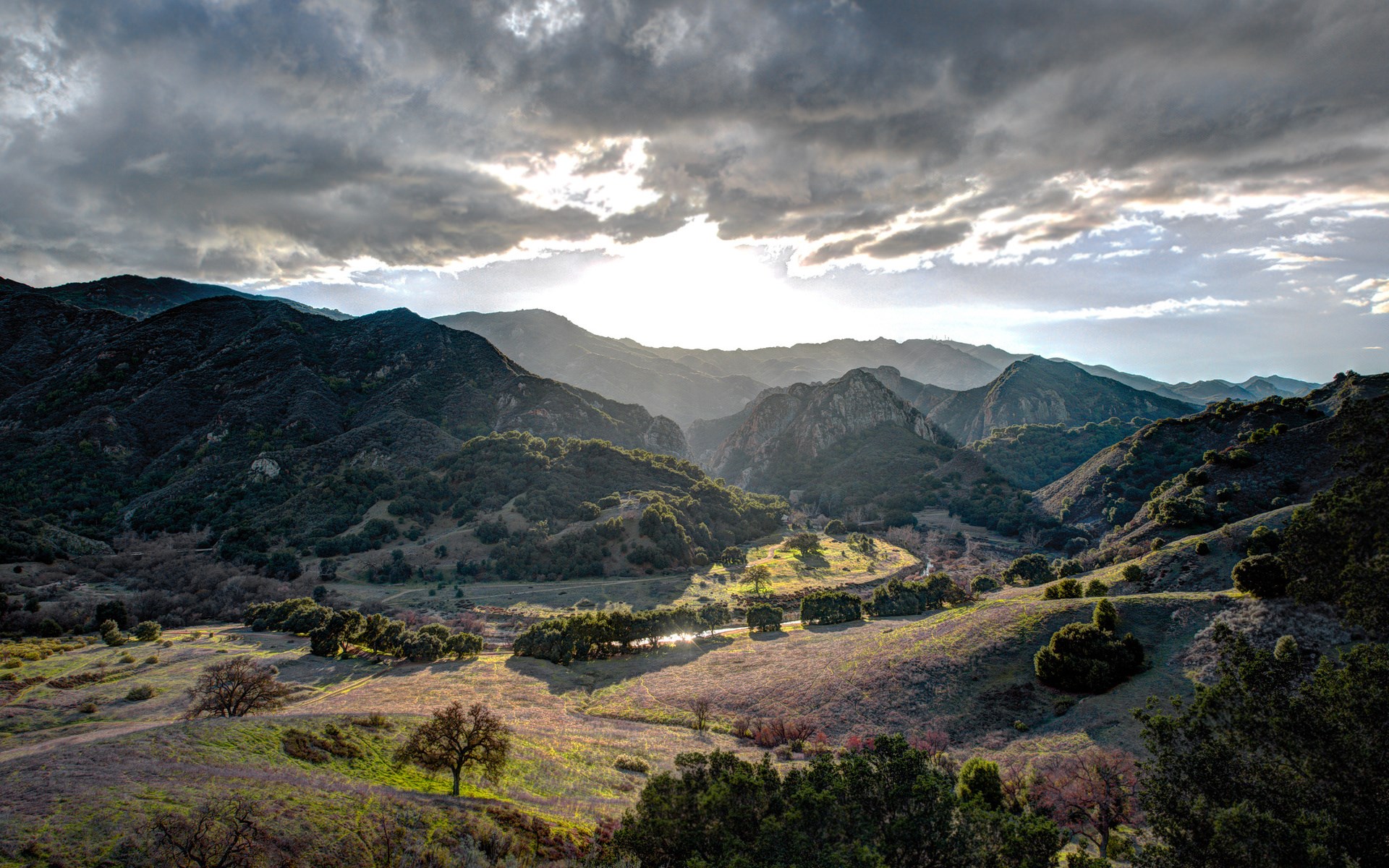 Mountain valley with sunbeams through clouds HD Wallpaper