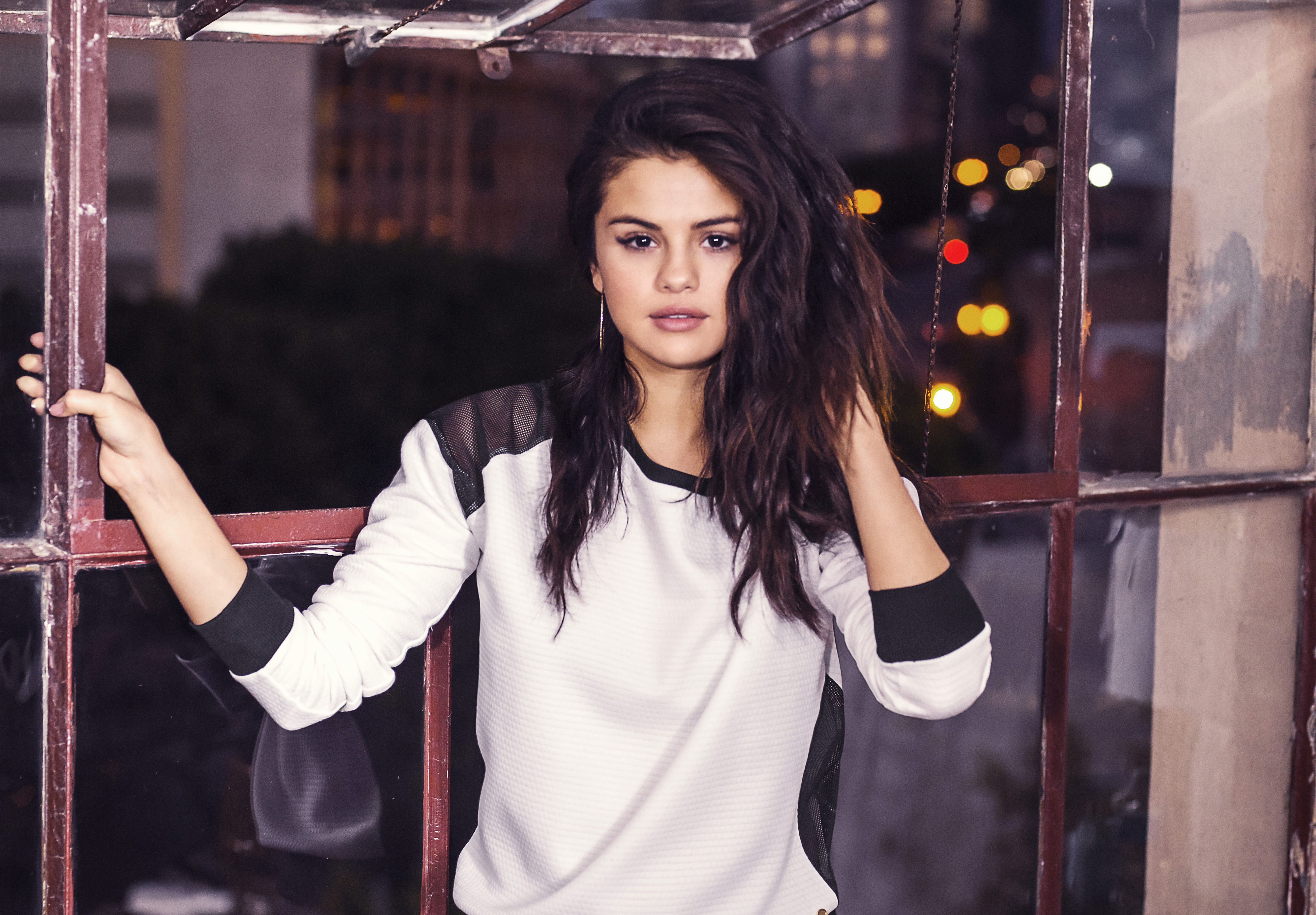 Selena Gomez posing by a window HD Wallpaper