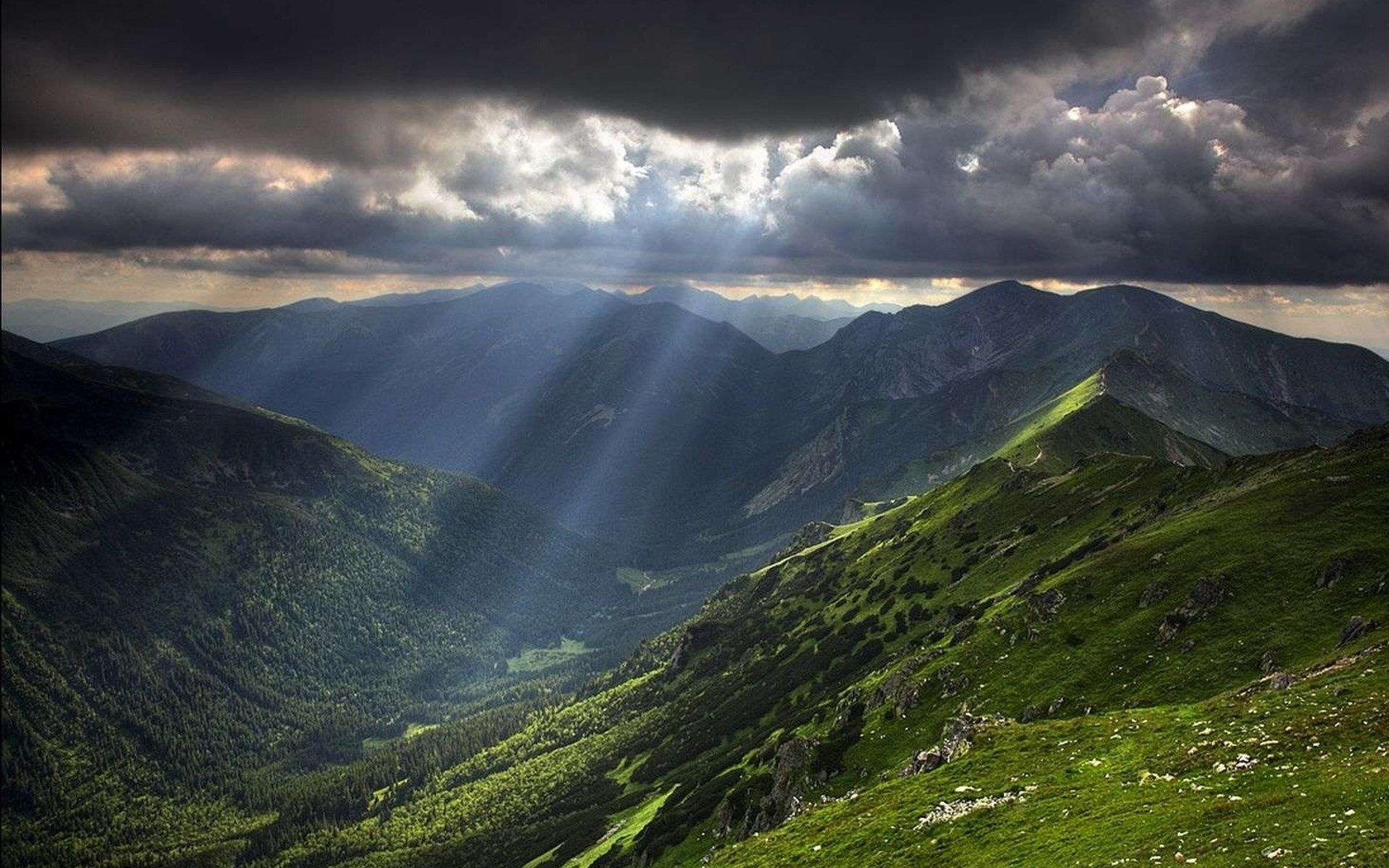 Sunbeams through clouds over a mountain valley HD Wallpaper