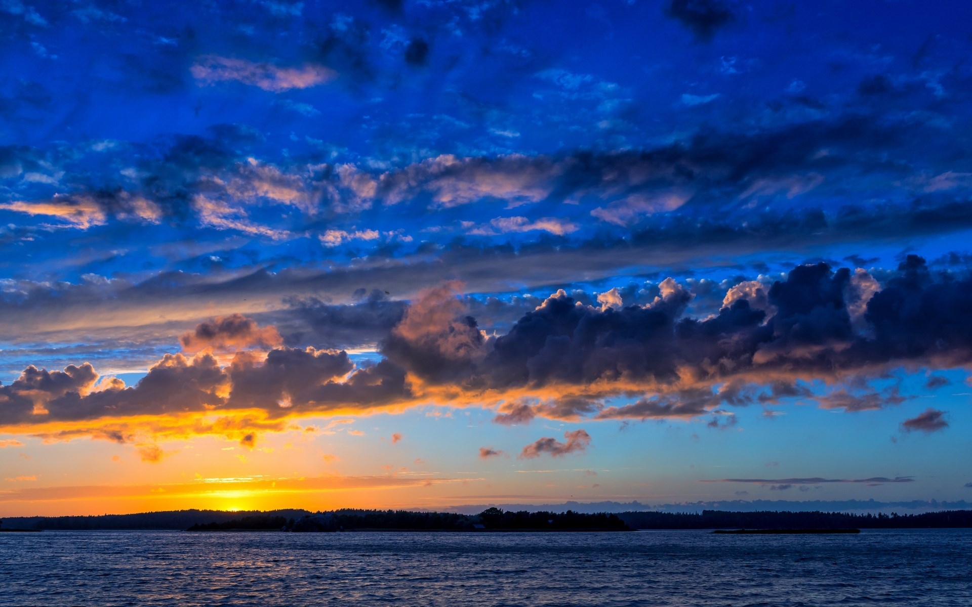 Sunset over water with dramatic clouds HD Wallpaper