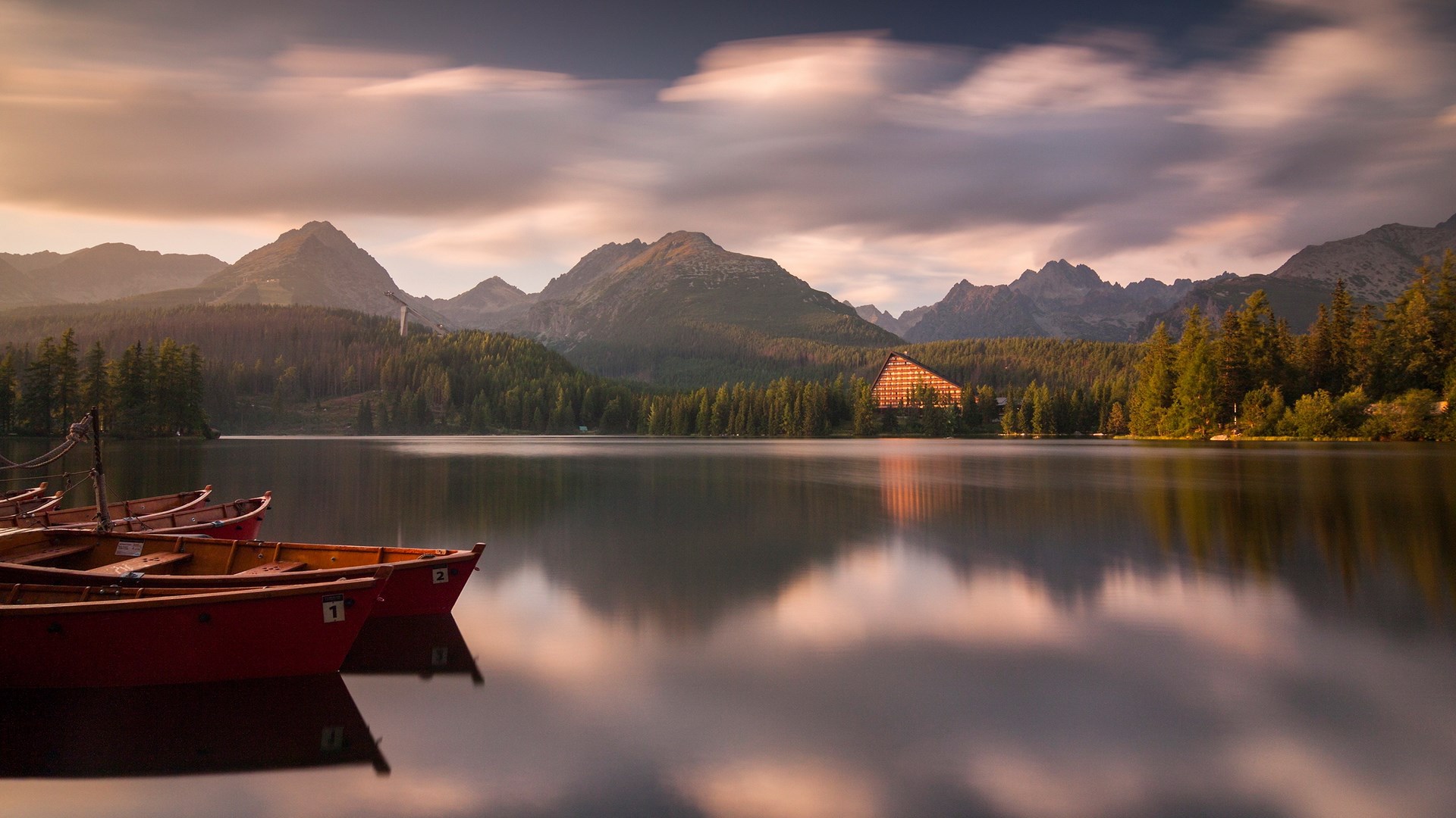 Boats on a lake with mountains and a hotel HD Wallpaper