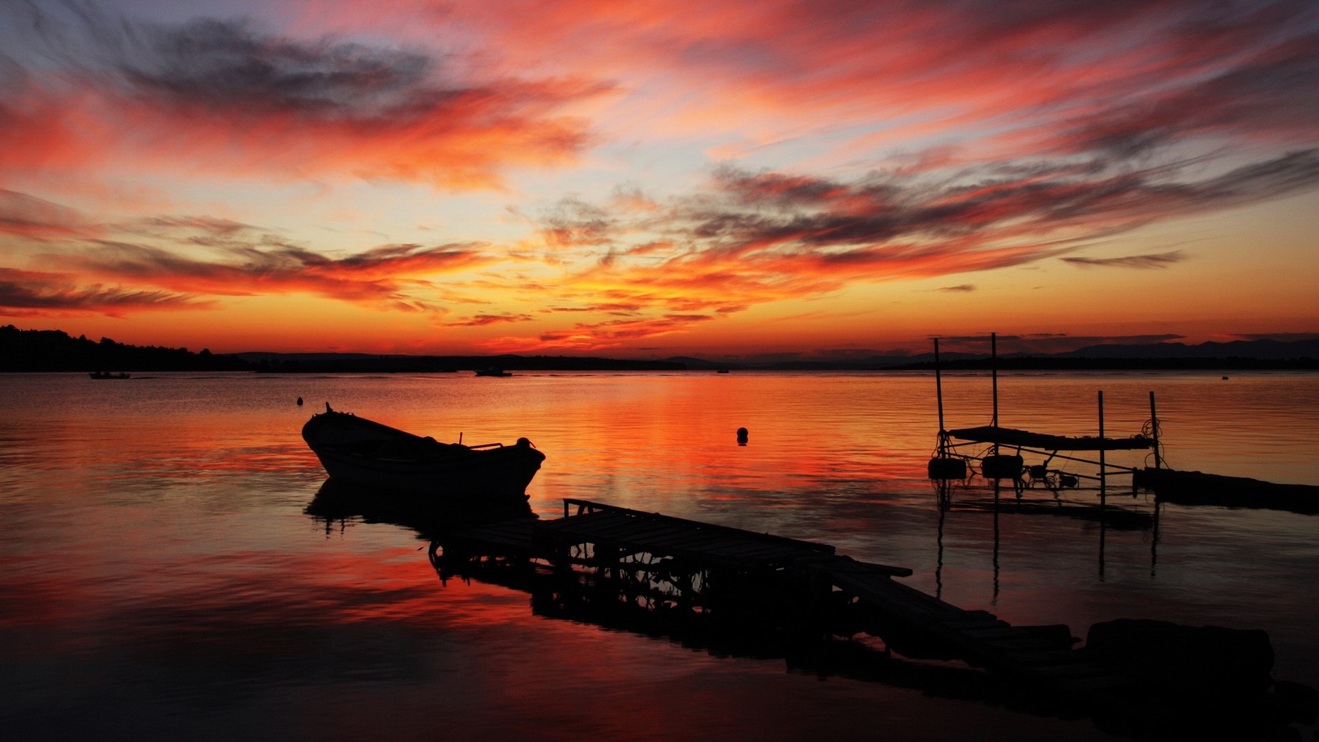 Sunset over a calm lake with a boat and pier HD Wallpaper