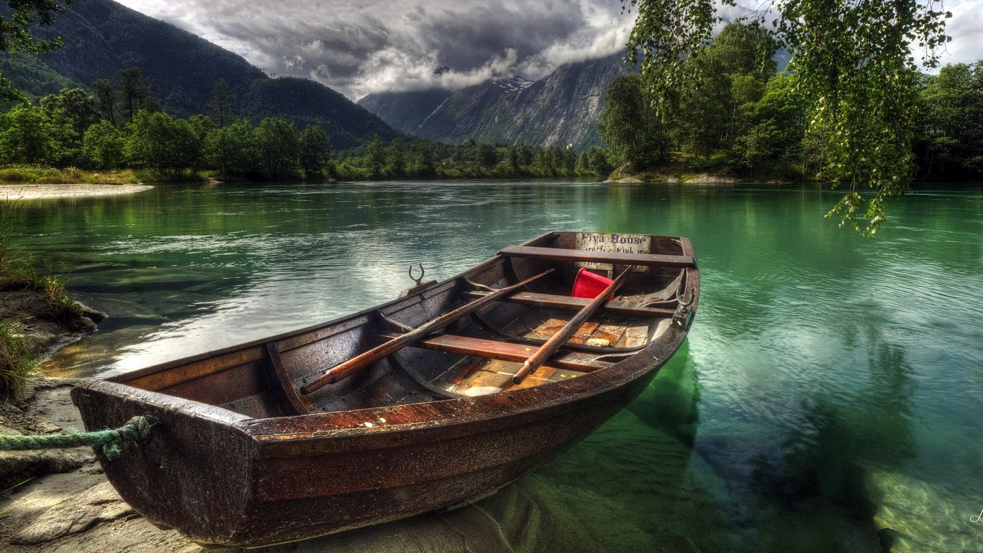 Wooden boat on a clear river with mountains HD Wallpaper