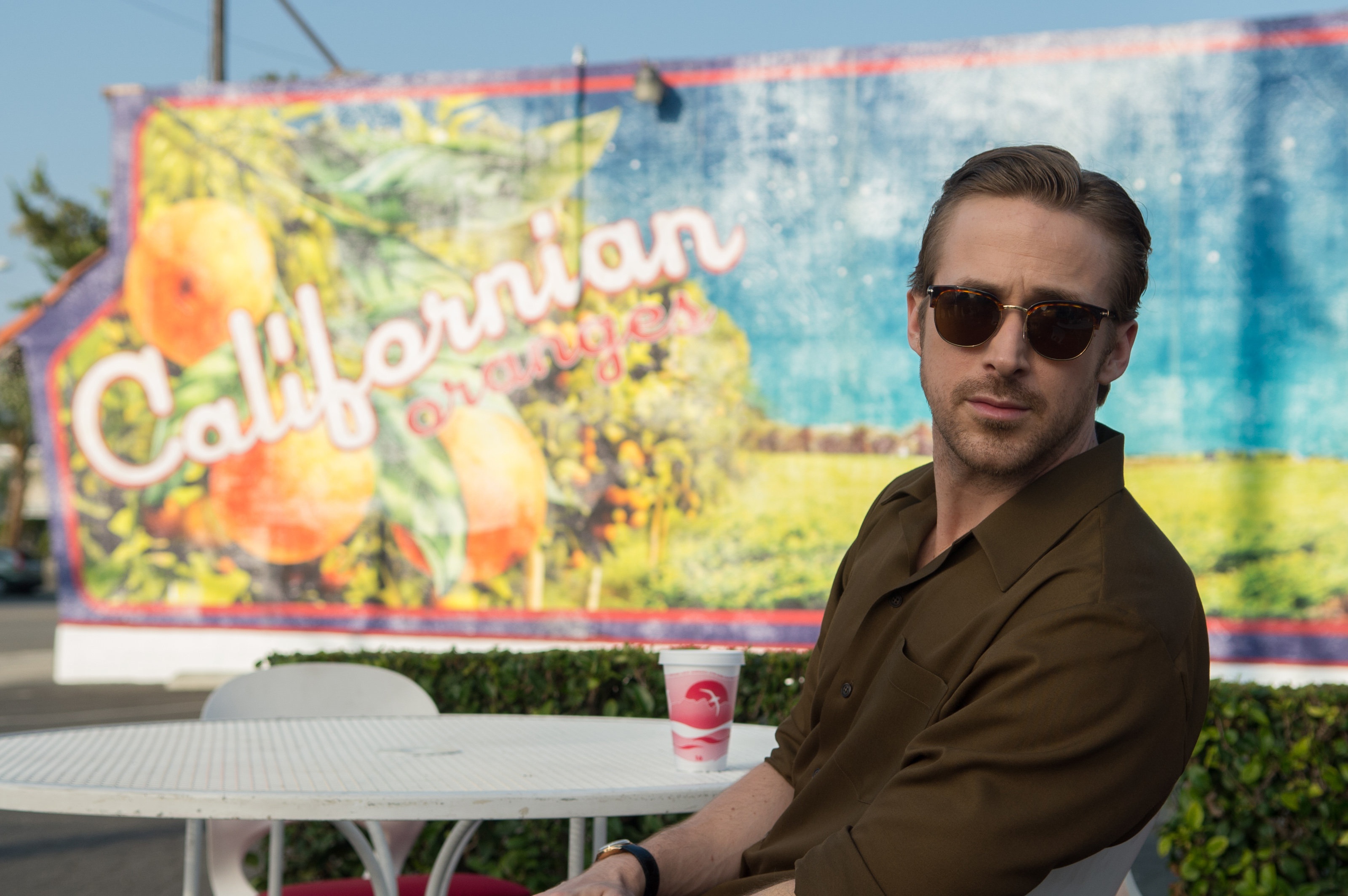 Ryan Gosling in front of Californian Oranges sign HD Wallpaper