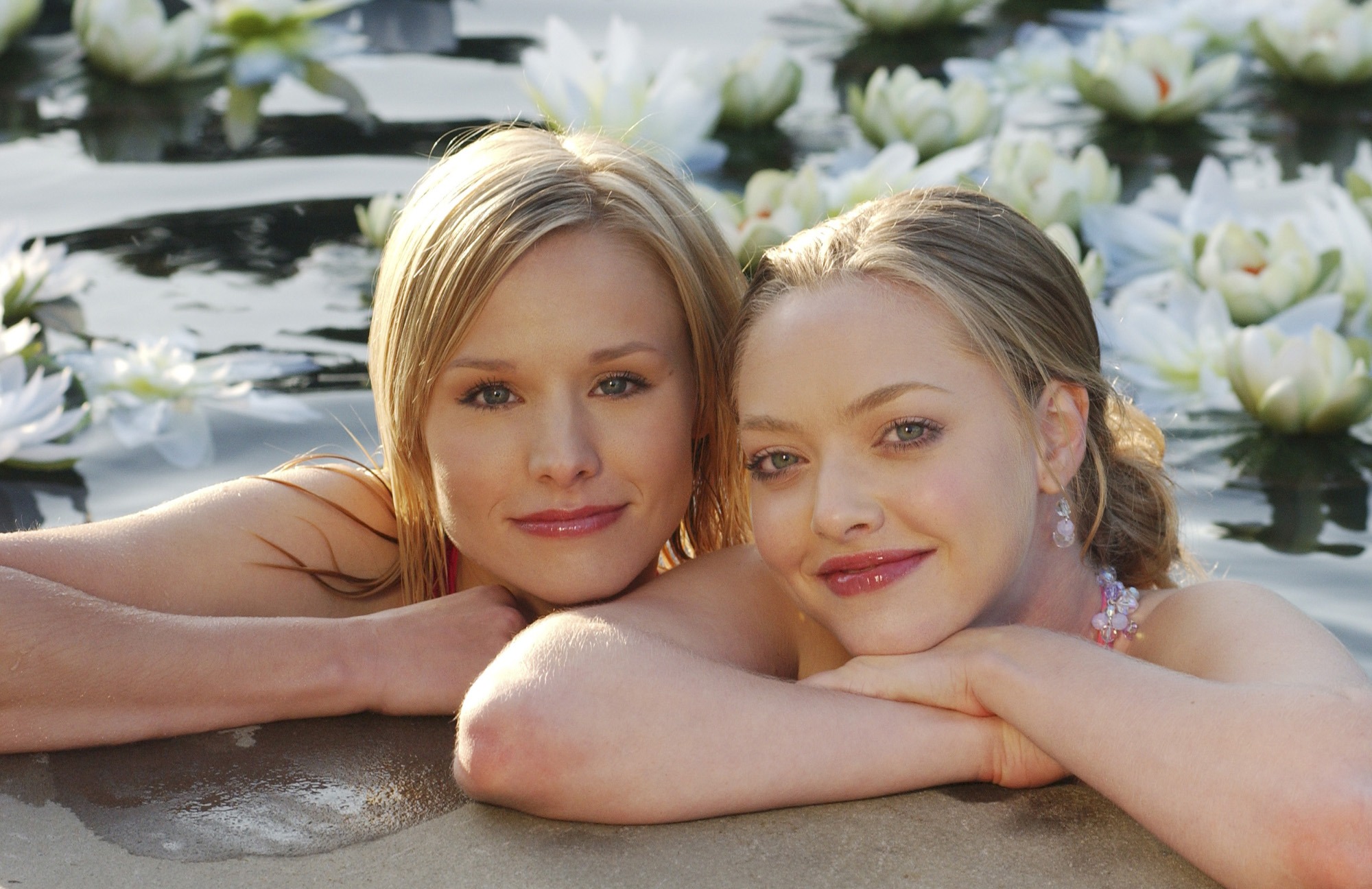 Kristen Bell and Amanda Seyfried in water with lilies HD Wallpaper
