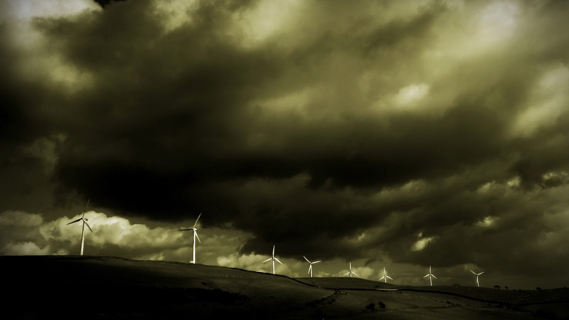 Wind turbines on a hill under stormy clouds HD Wallpaper