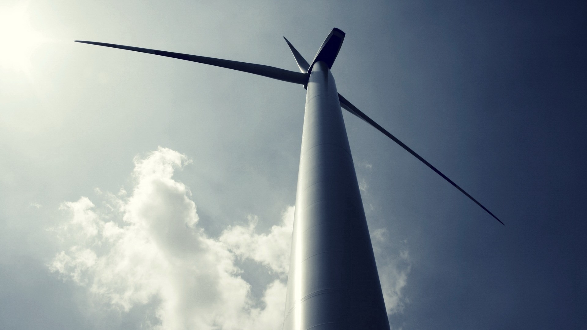 Wind turbine against a cloudy sky HD Wallpaper