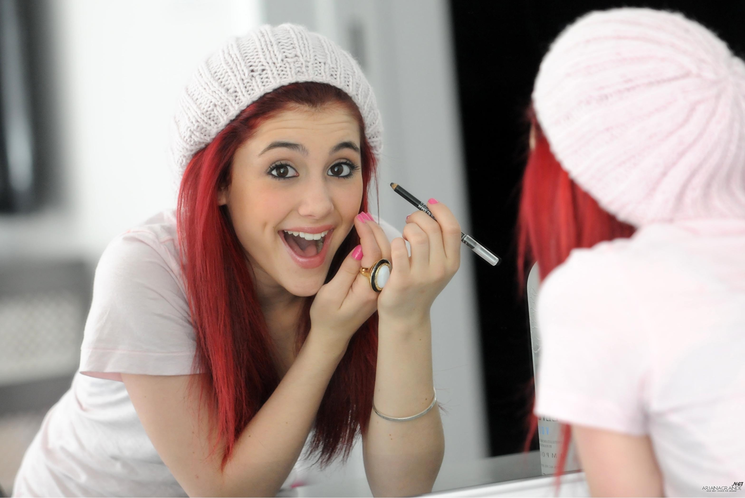 Ariana Grande applying makeup in a mirror HD Wallpaper