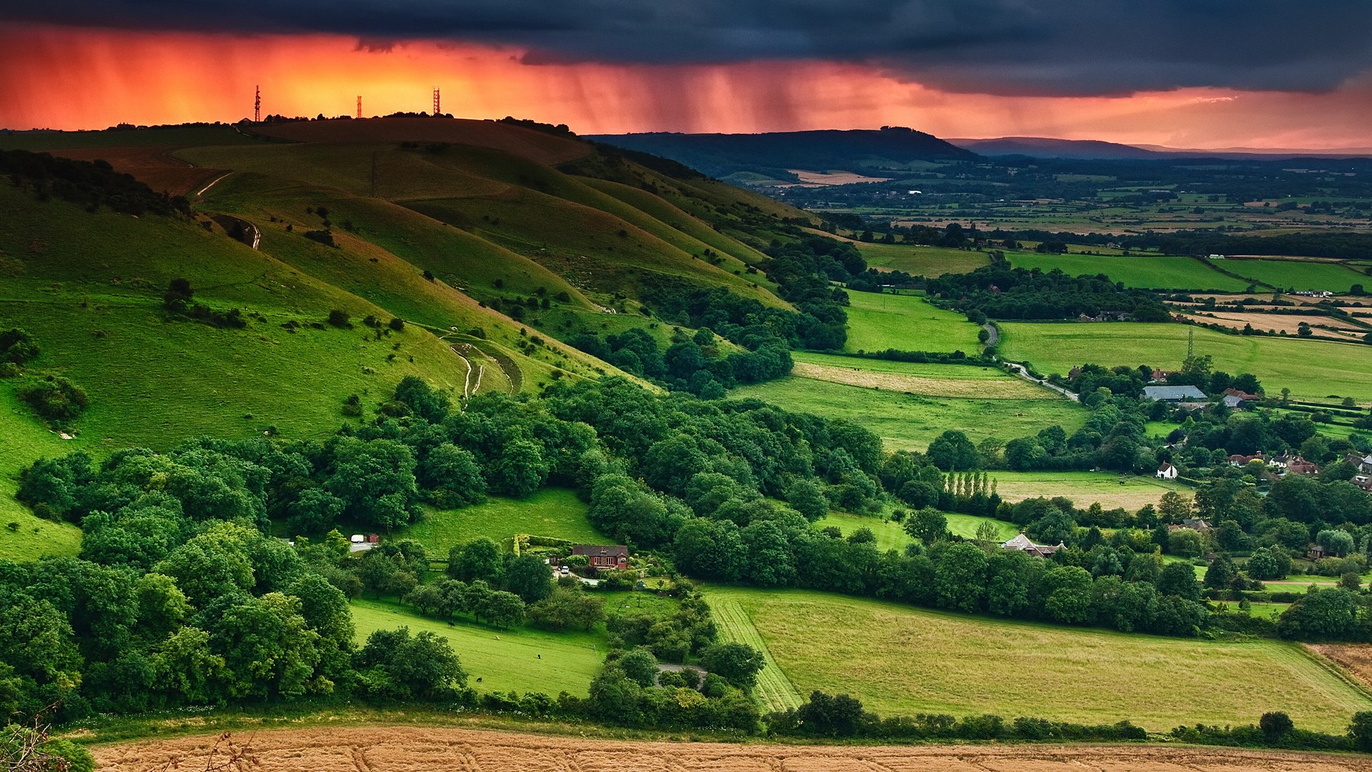 Rolling green hills with a dramatic sunset sky HD Wallpaper