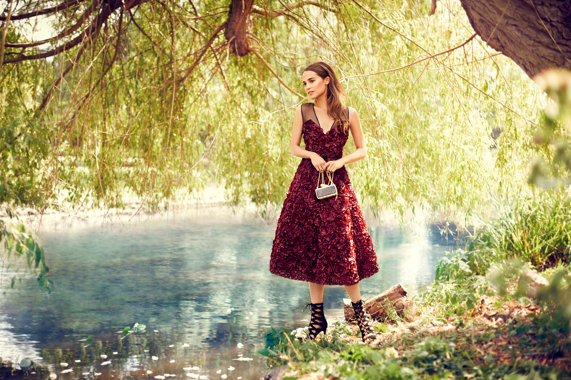 Alicia Vikander in a red dress by a river HD Wallpaper