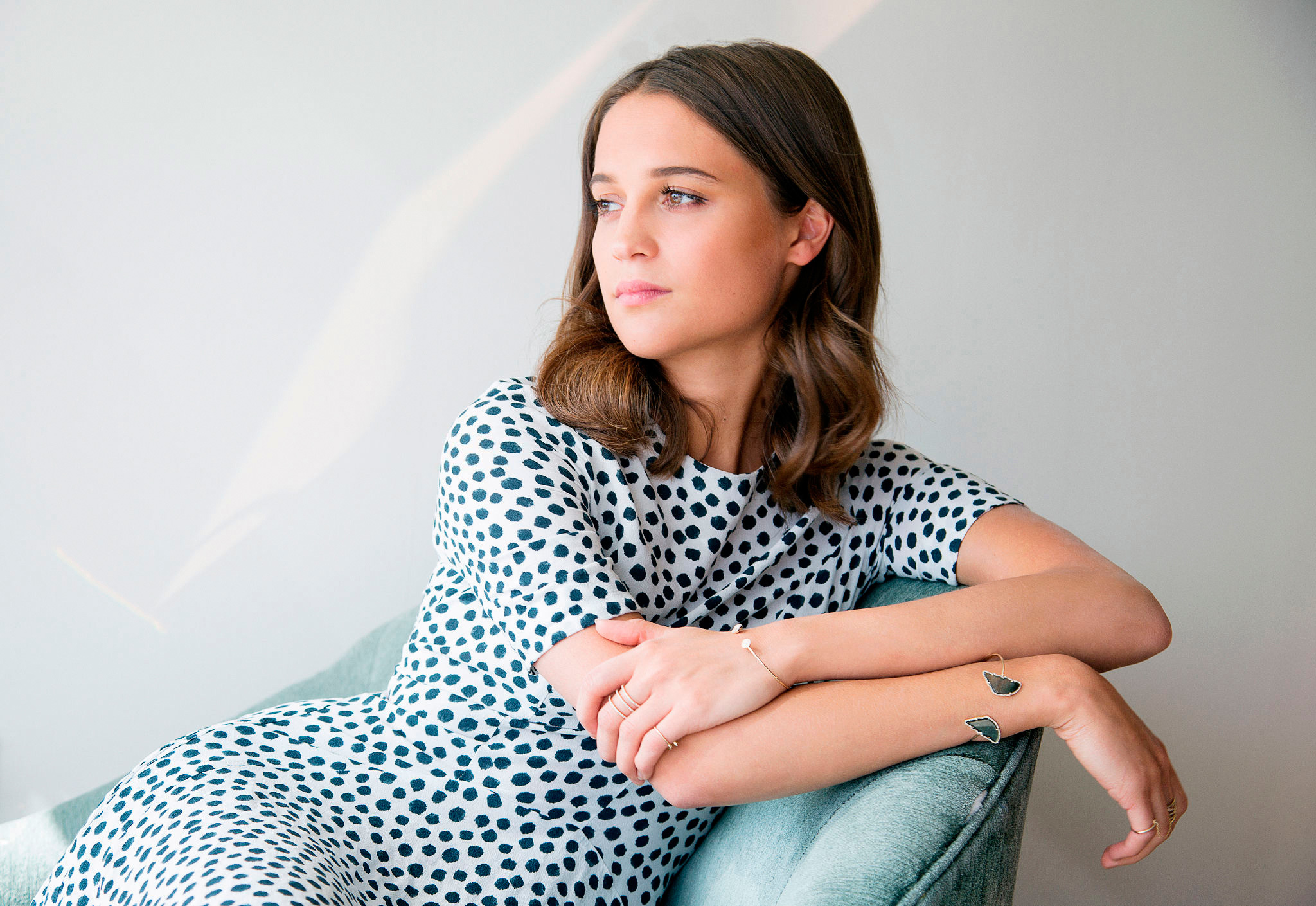 Alicia Vikander sitting on a chair HD Wallpaper