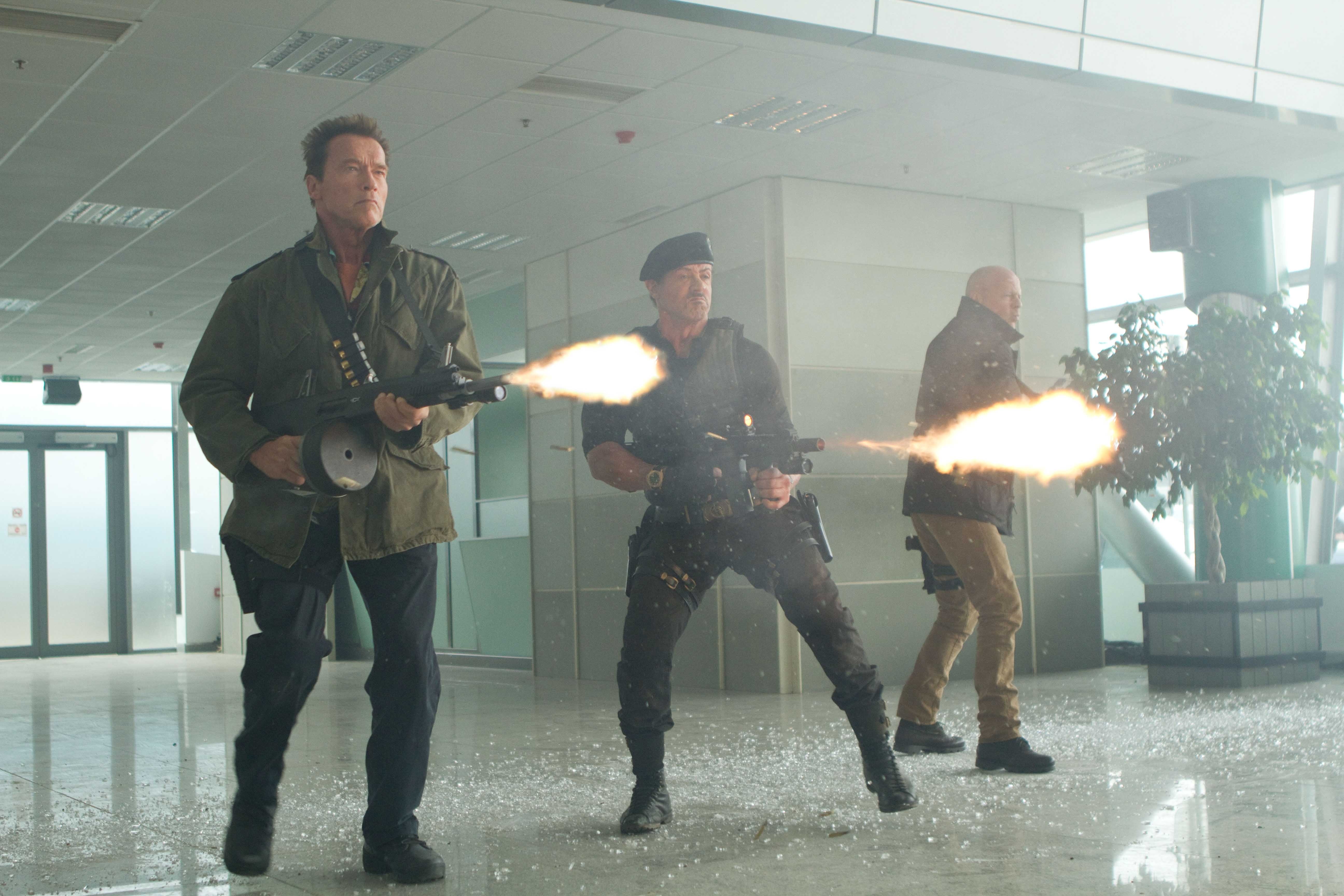 Arnold Schwarzenegger and Sylvester Stallone firing weapons HD Wallpaper