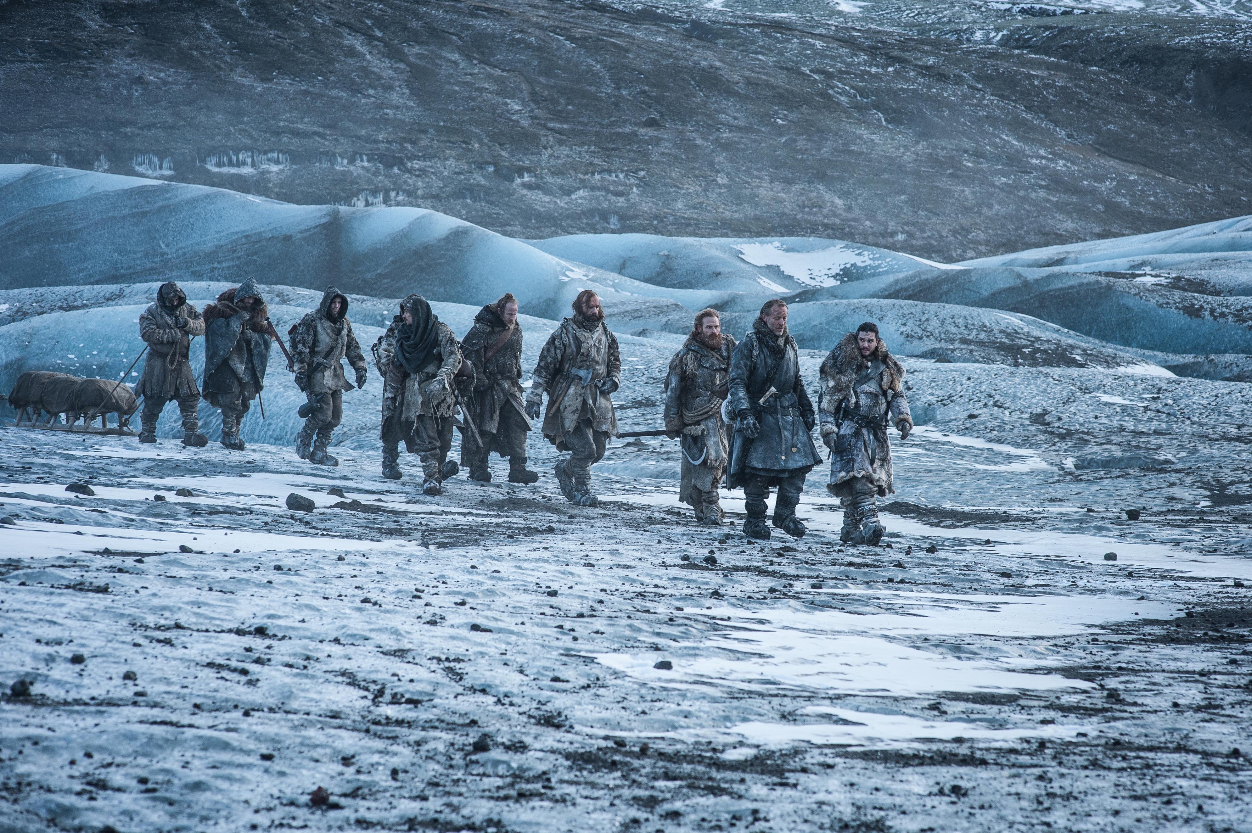 Group of men walking across a frozen landscape HD Wallpaper