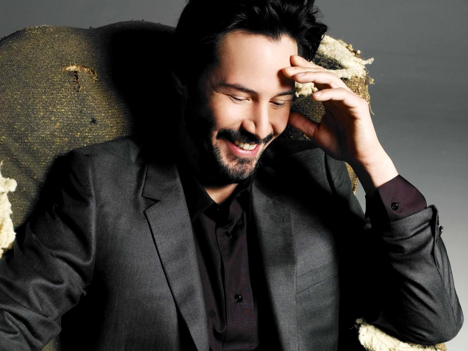 Keanu Reeves sitting in a chair HD Wallpaper