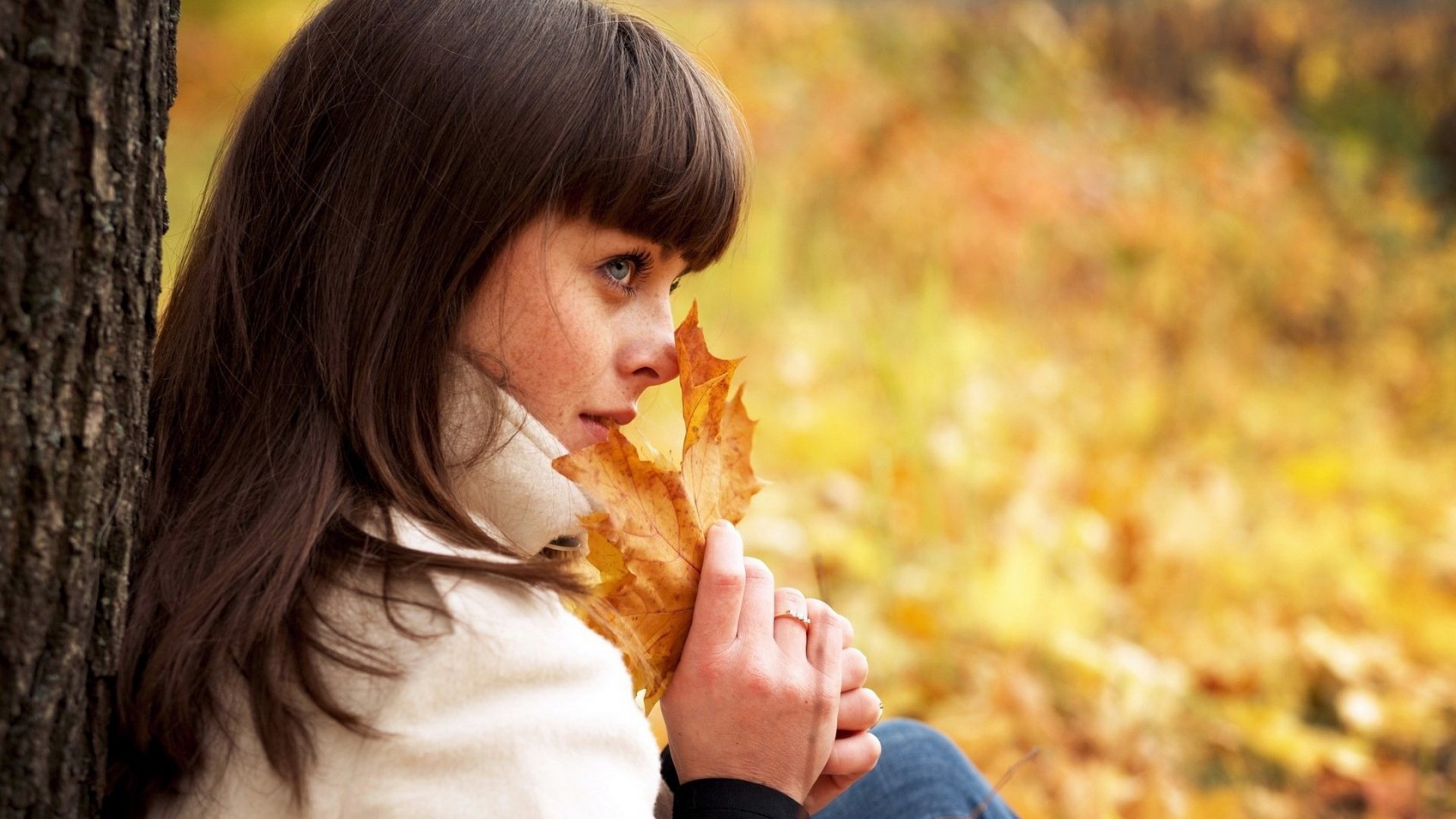 Woman holding a leaf in autumn HD Wallpaper