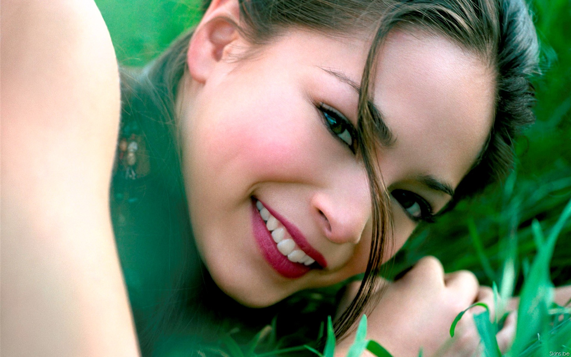 Kristin Kreuk smiling in grass HD Wallpaper