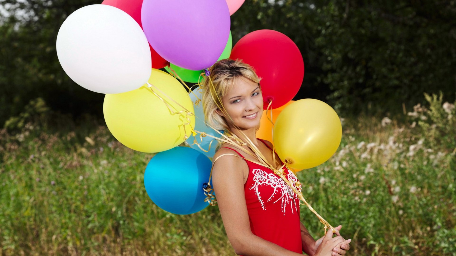 Woman holding a bunch of colorful balloons HD Wallpaper