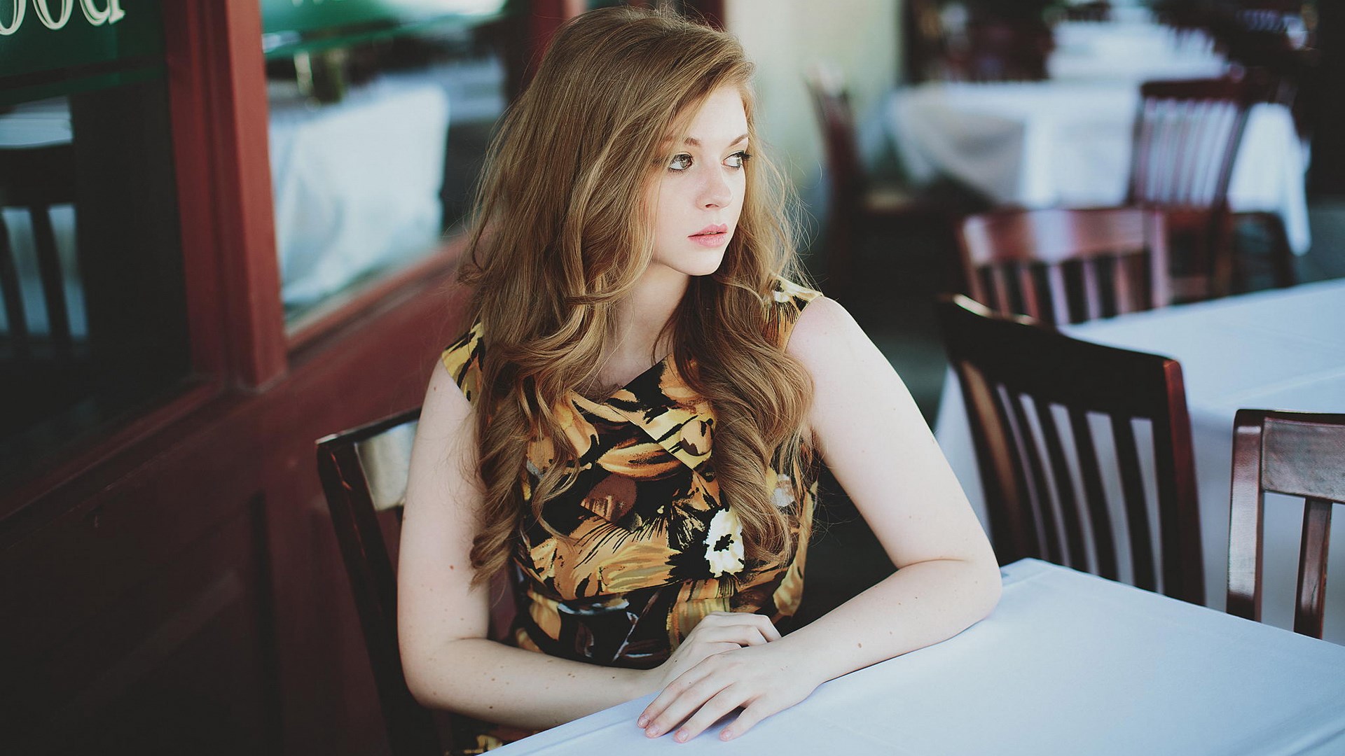 Woman sitting at a table in a restaurant HD Wallpaper