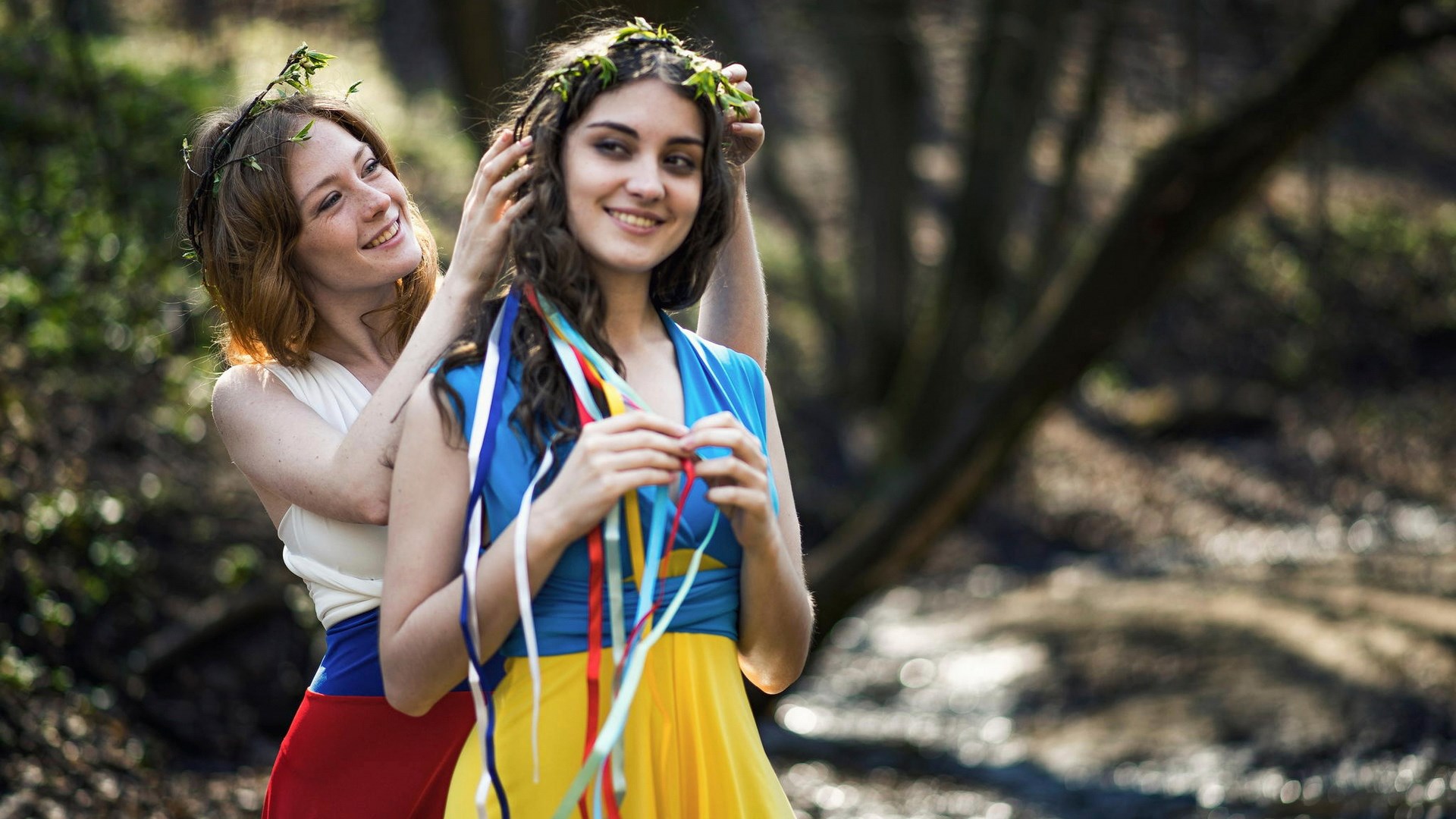 Two women with flower crowns in a forest HD Wallpaper