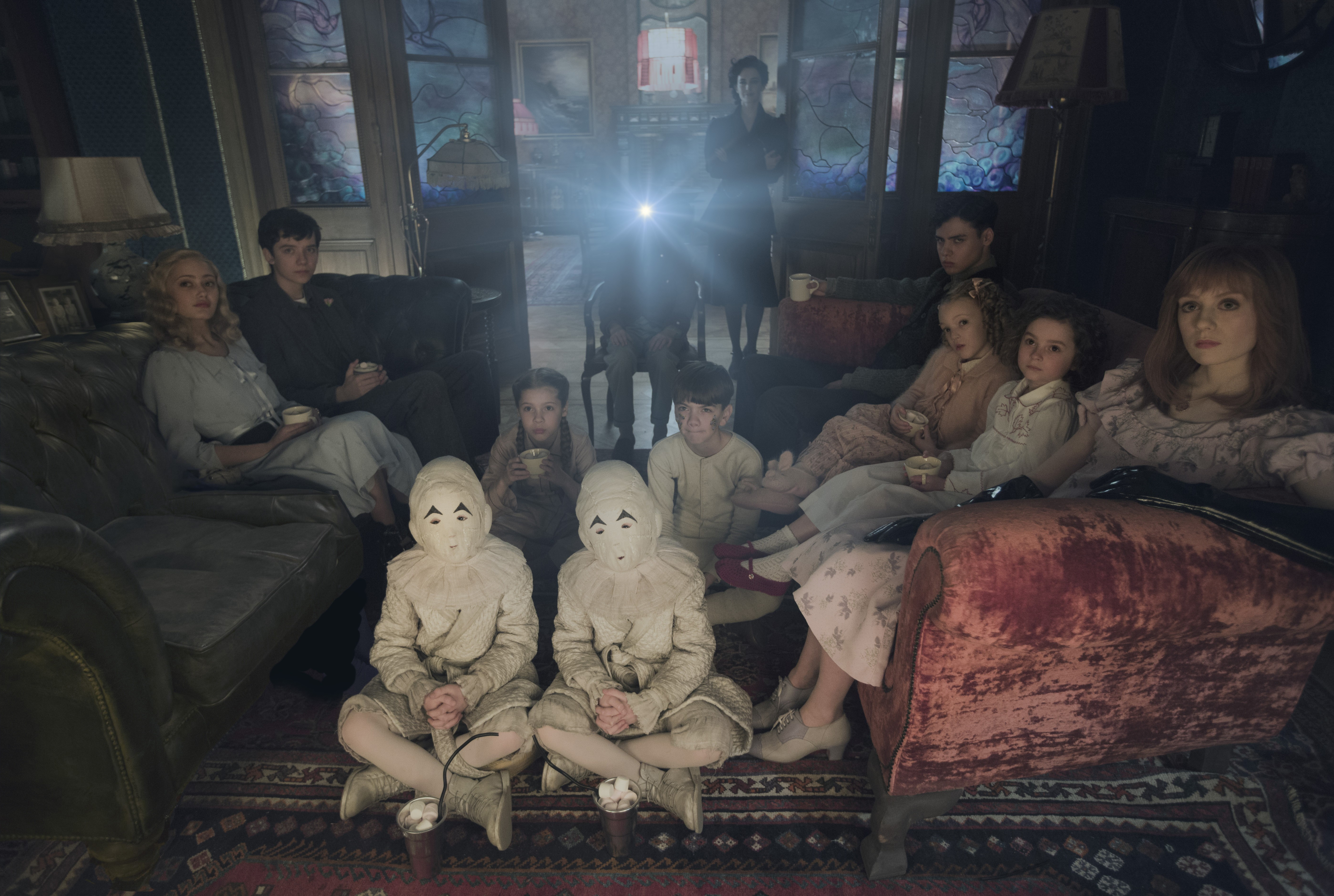 Children and adults watching a projector in a dimly lit room HD Wallpaper