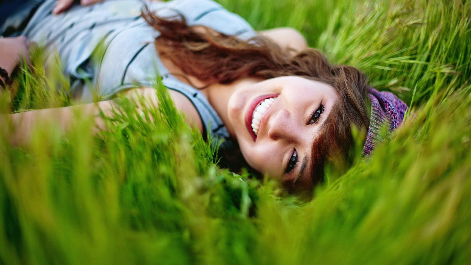 Young woman lying in grass HD Wallpaper