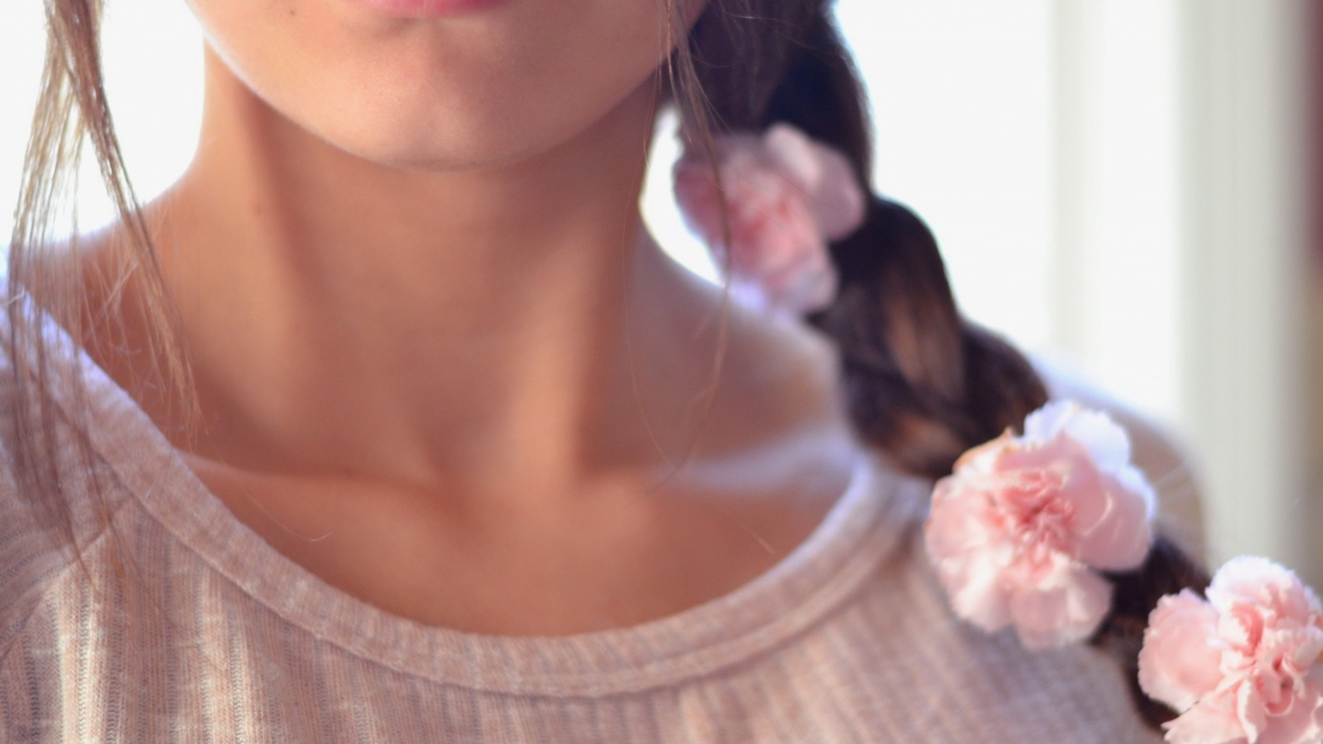 Close-up of a person with flowers in their braid HD Wallpaper