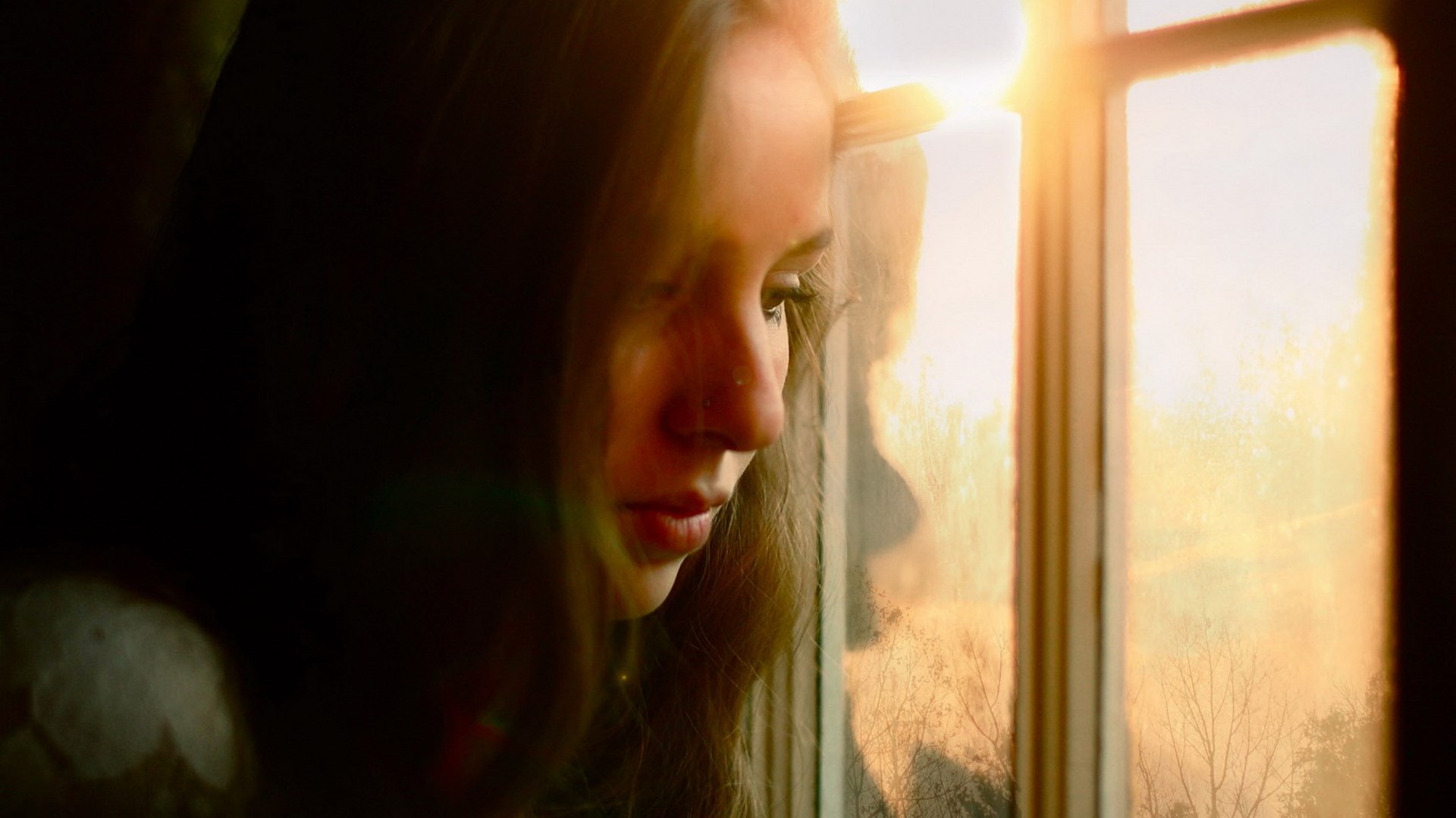 Girl looking out a window at sunset HD Wallpaper