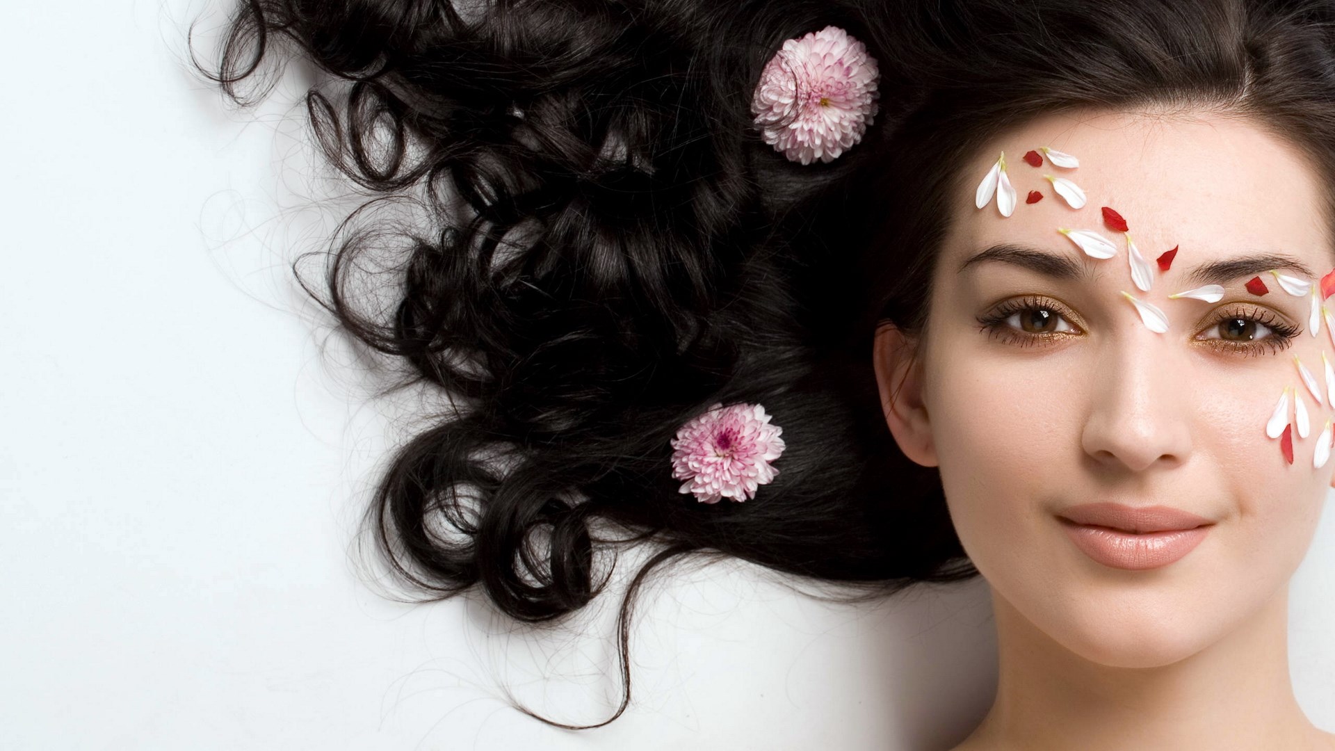 Woman with flowers and petals on her face and hair HD Wallpaper
