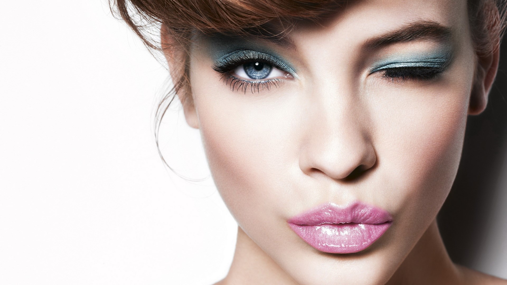 Woman with blue eyeshadow and pink lips winking HD Wallpaper