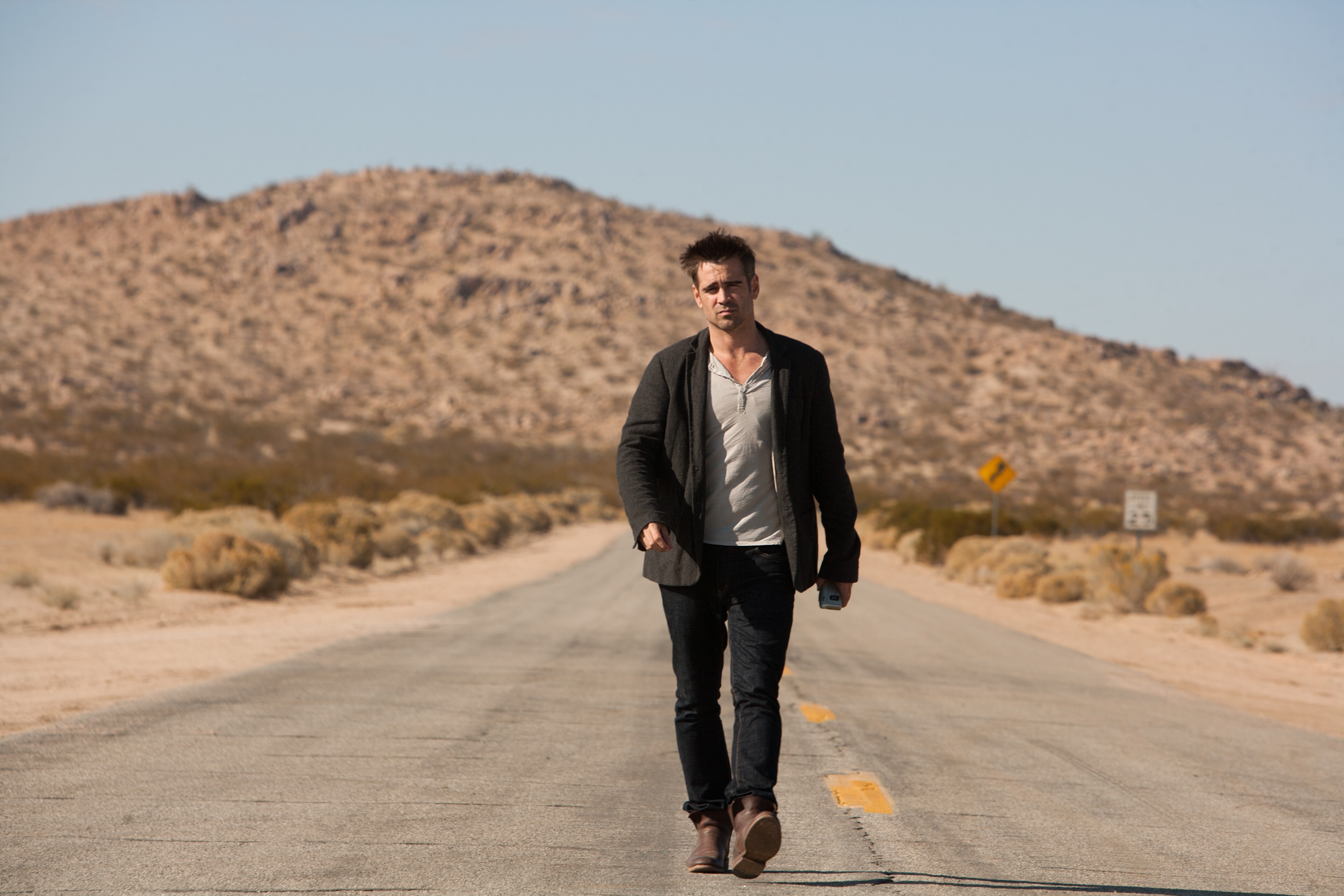Colin Farrell walking on a desert road HD Wallpaper