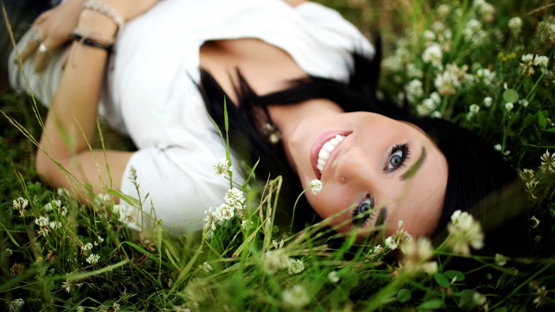 Woman lying in grass with flowers HD Wallpaper