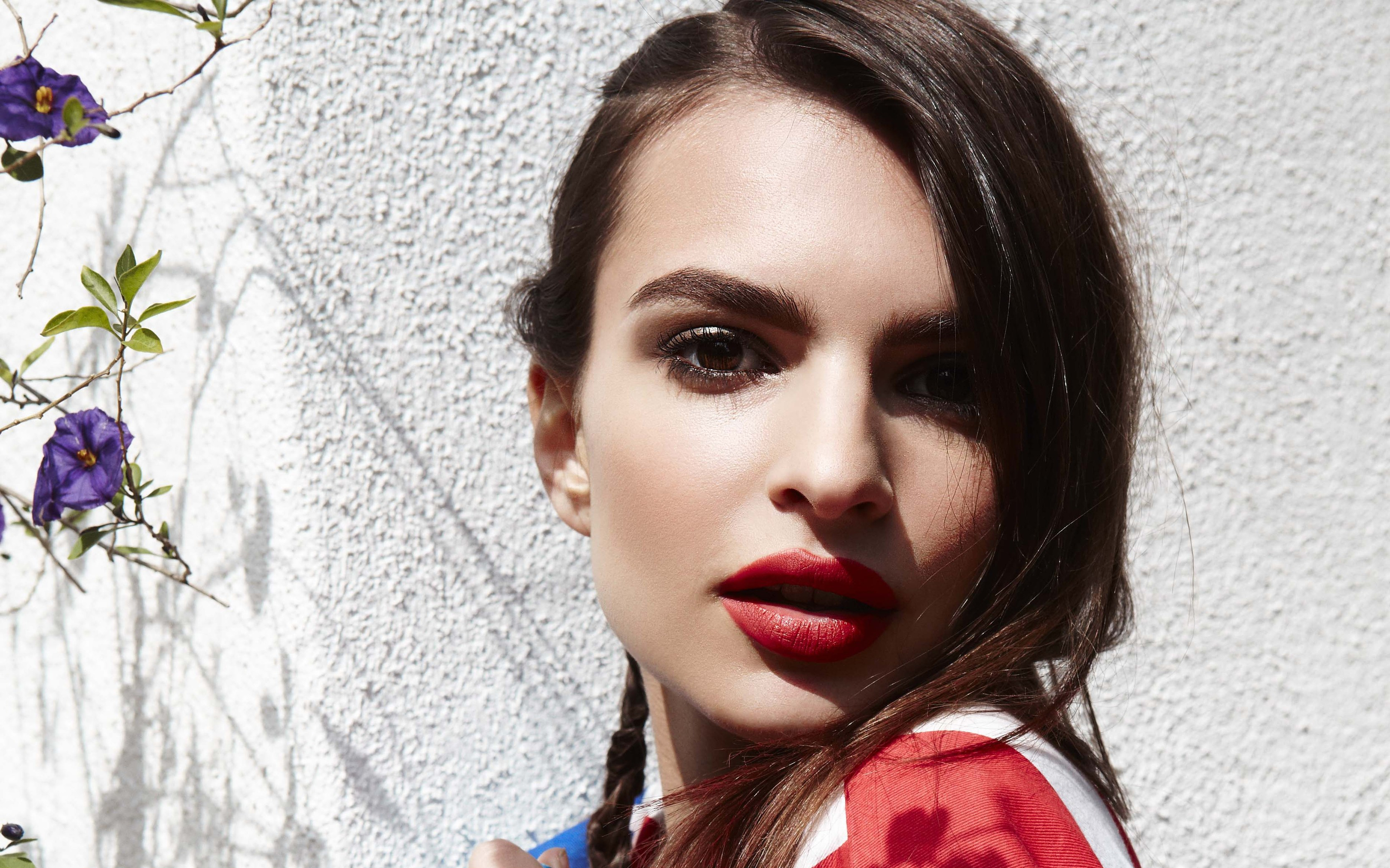 Emily Ratajkowski posing against a textured wall HD Wallpaper