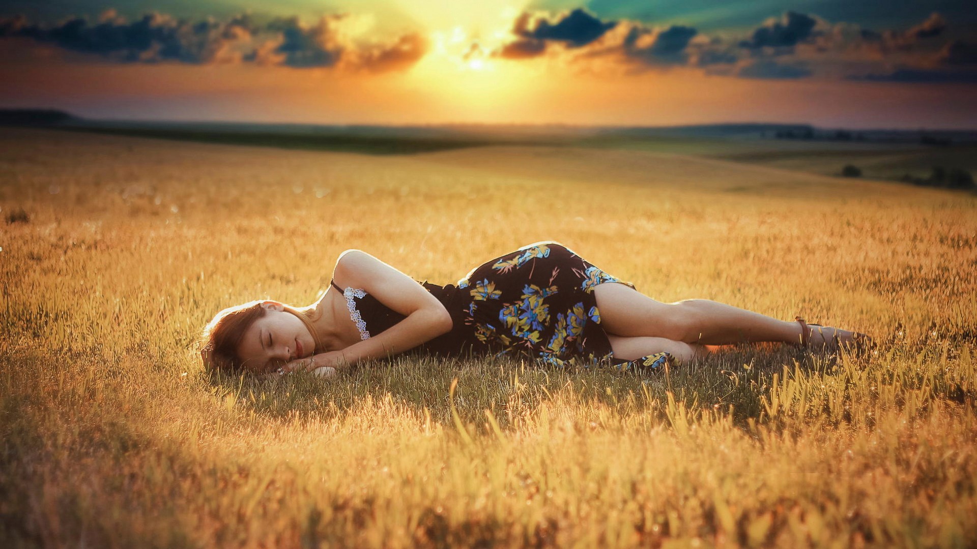 Woman sleeping in a field at sunset HD Wallpaper