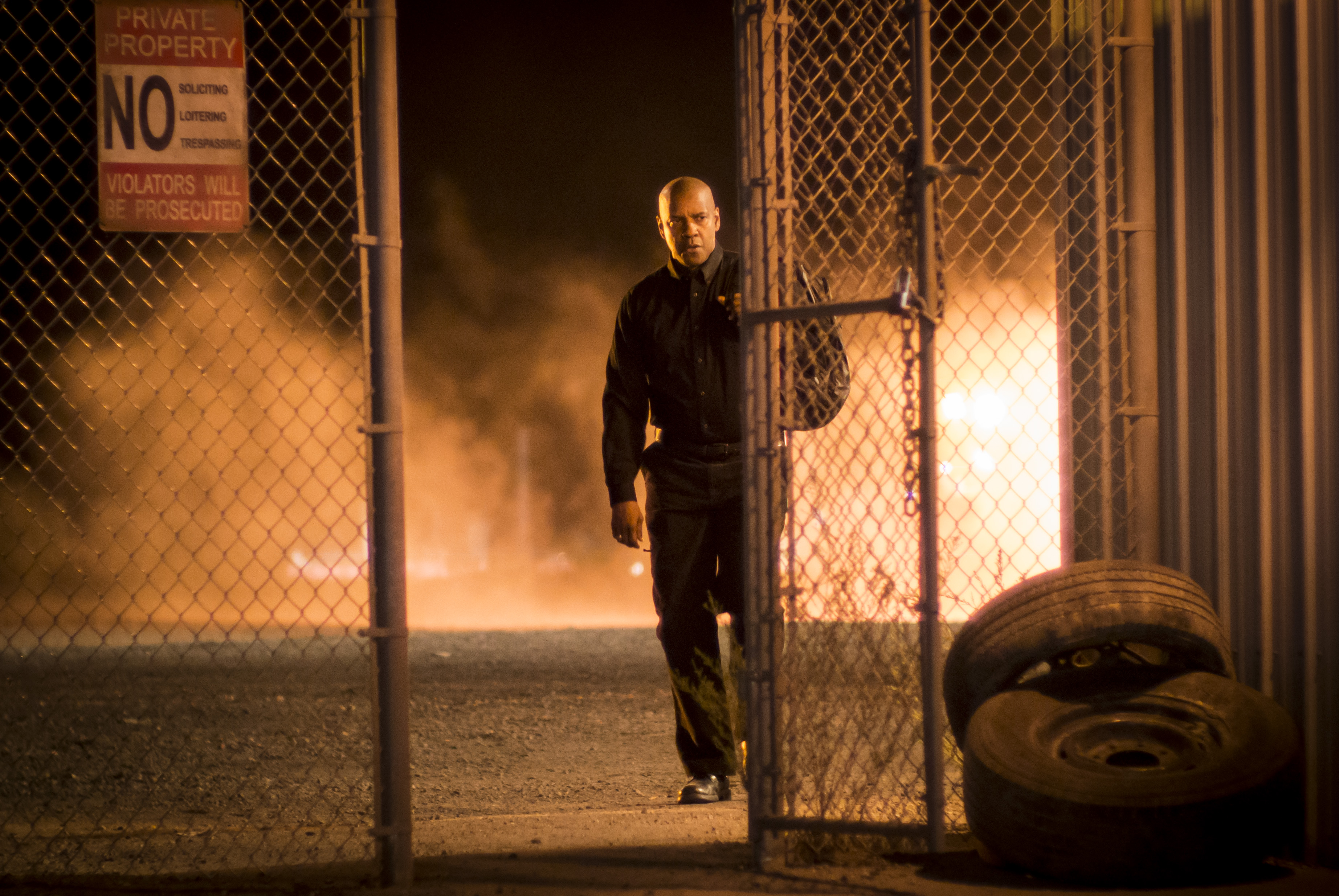 Denzel Washington walks through a gate at night HD Wallpaper