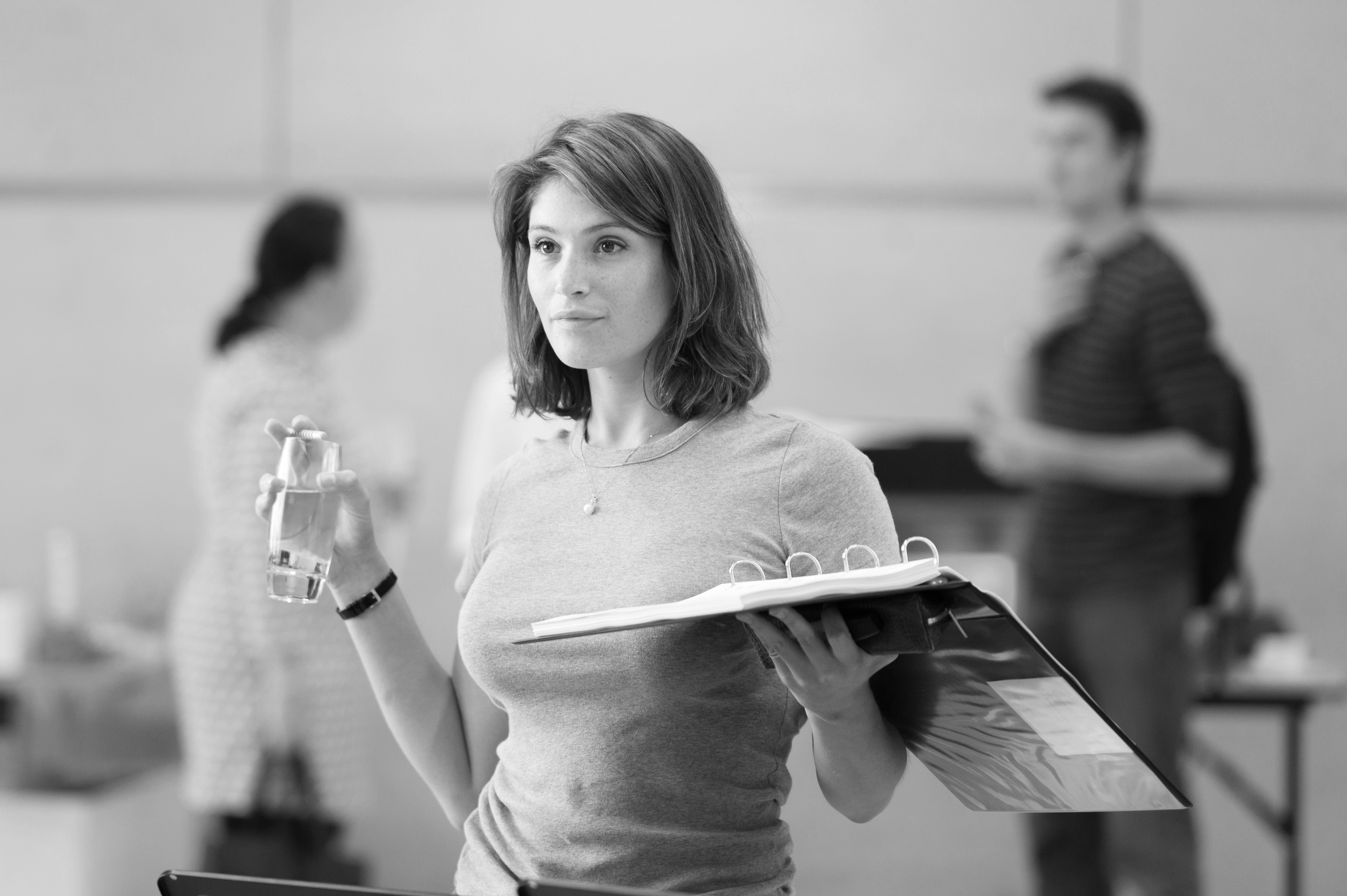 Gemma Arterton holding a glass of water and a binder HD Wallpaper