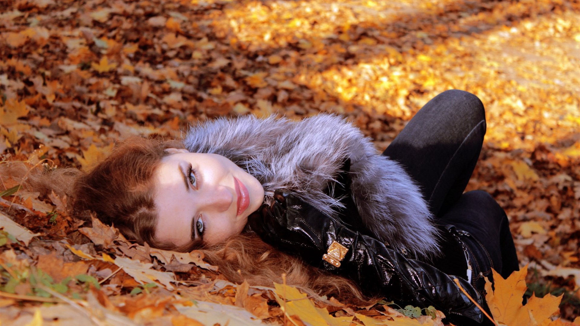 Woman lying in autumn leaves HD Wallpaper