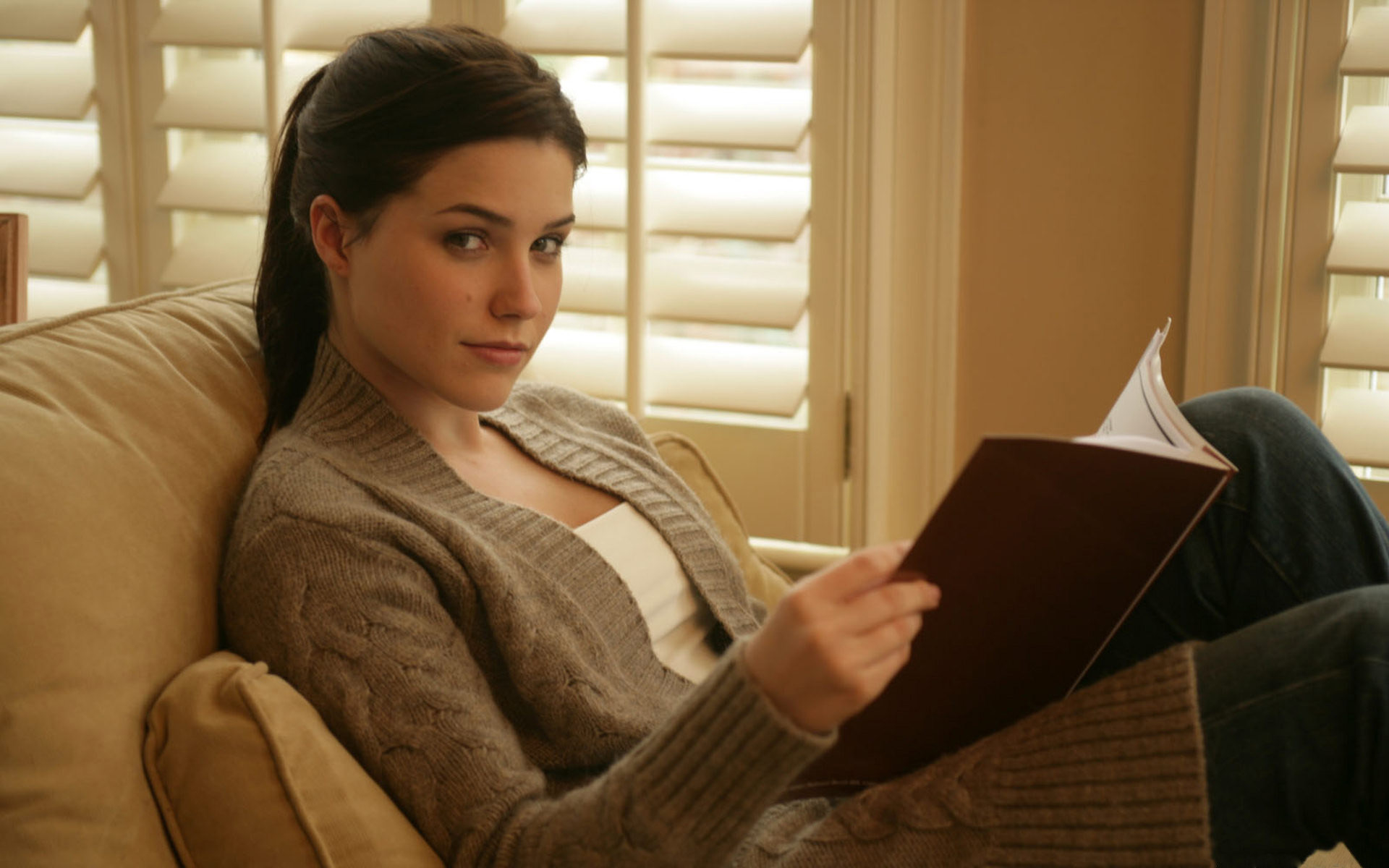 Sophia Bush reading a book on a couch HD Wallpaper