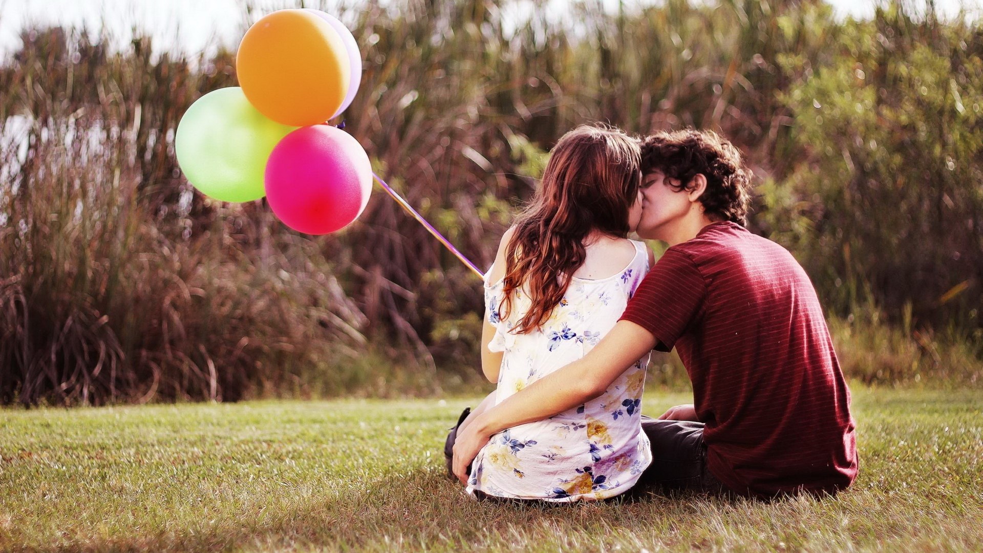 Couple kissing outdoors with balloons HD Wallpaper
