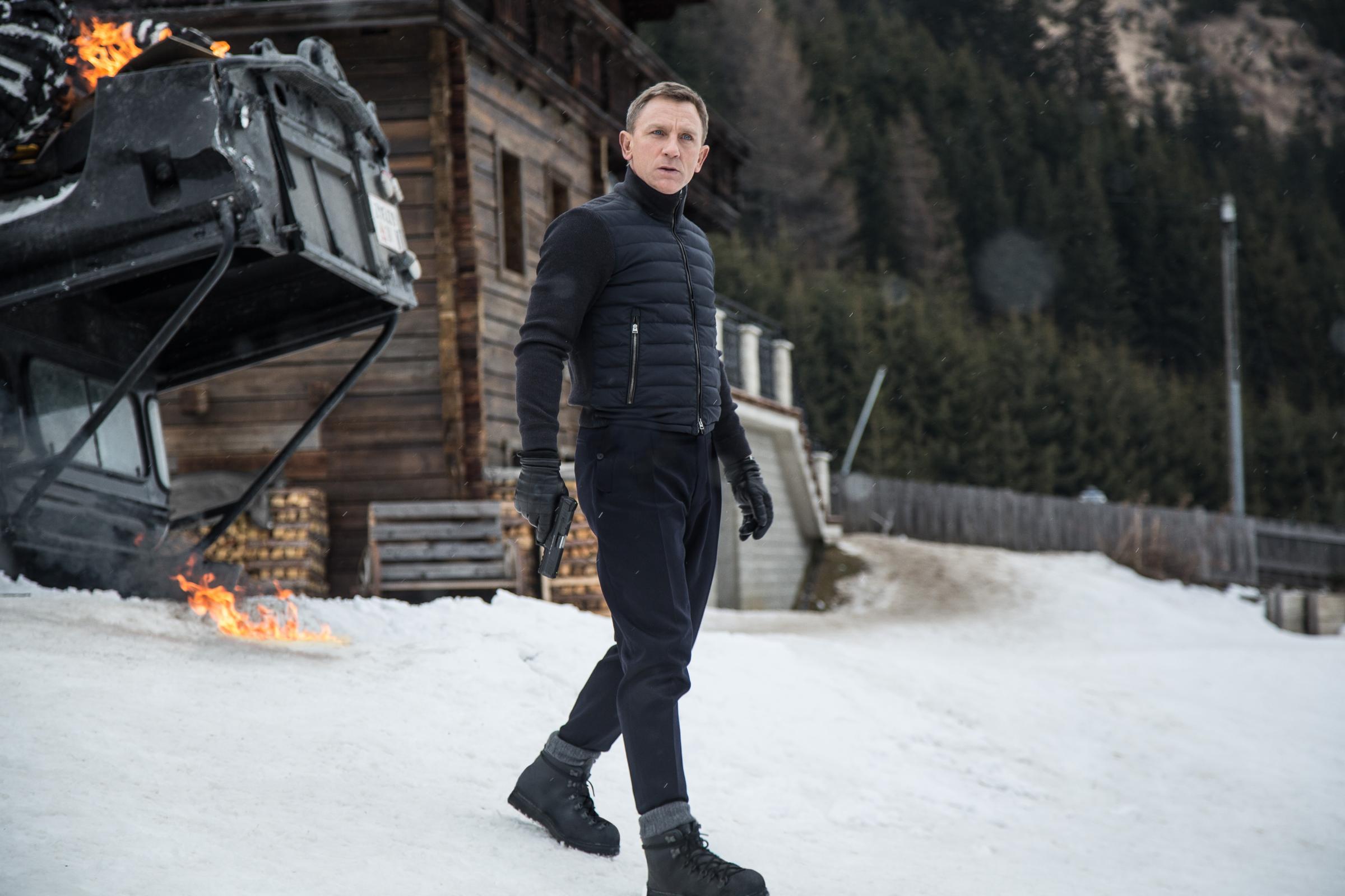 Daniel Craig in a snowy landscape with a burning vehicle HD Wallpaper