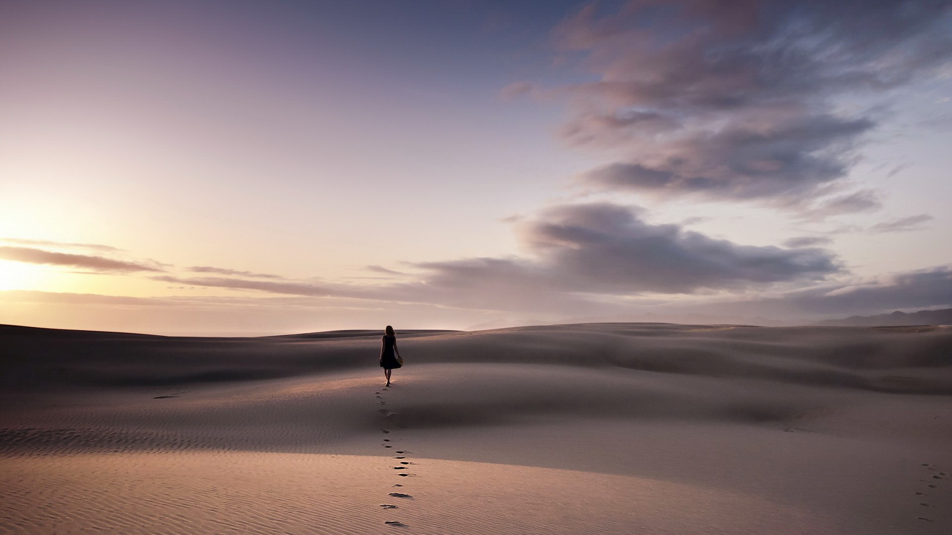 Woman walking on sand dunes at sunset HD Wallpaper