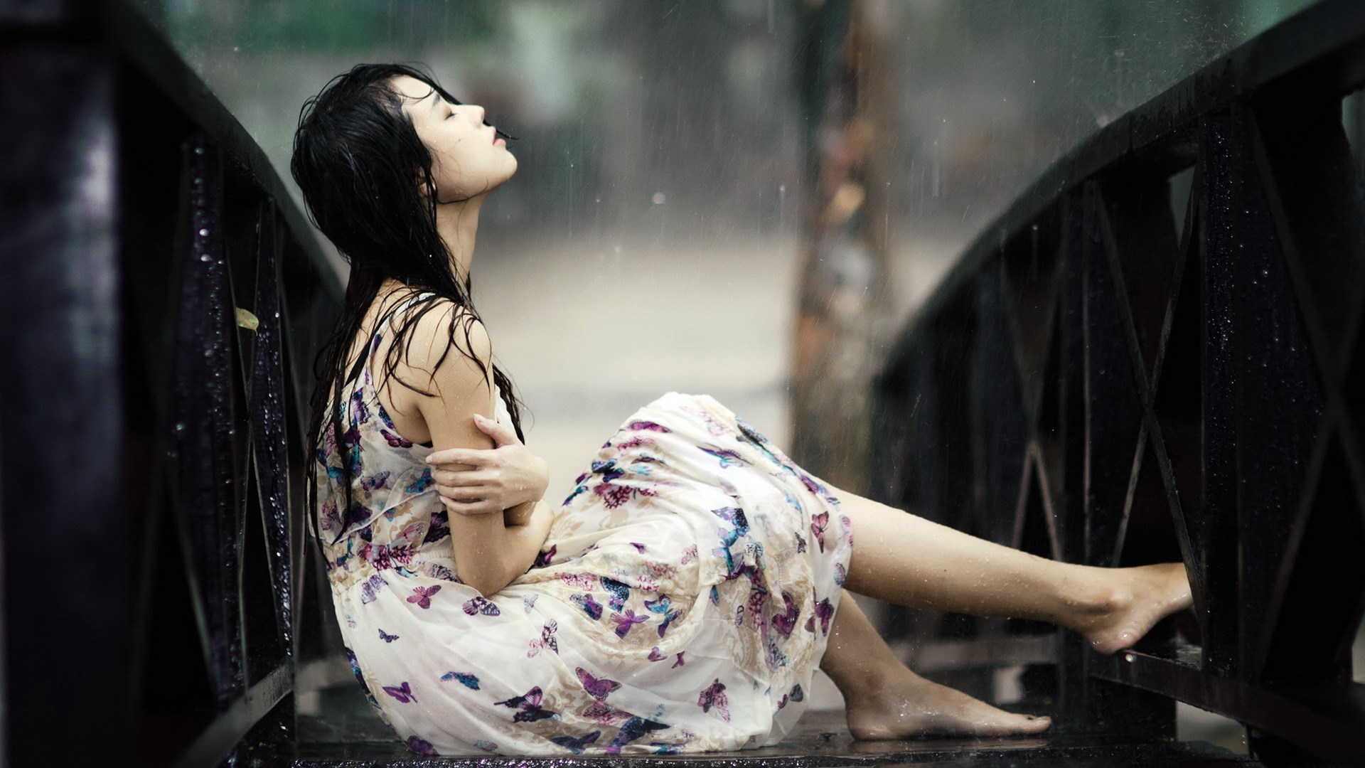 Woman in dress sitting on a bridge in the rain HD Wallpaper