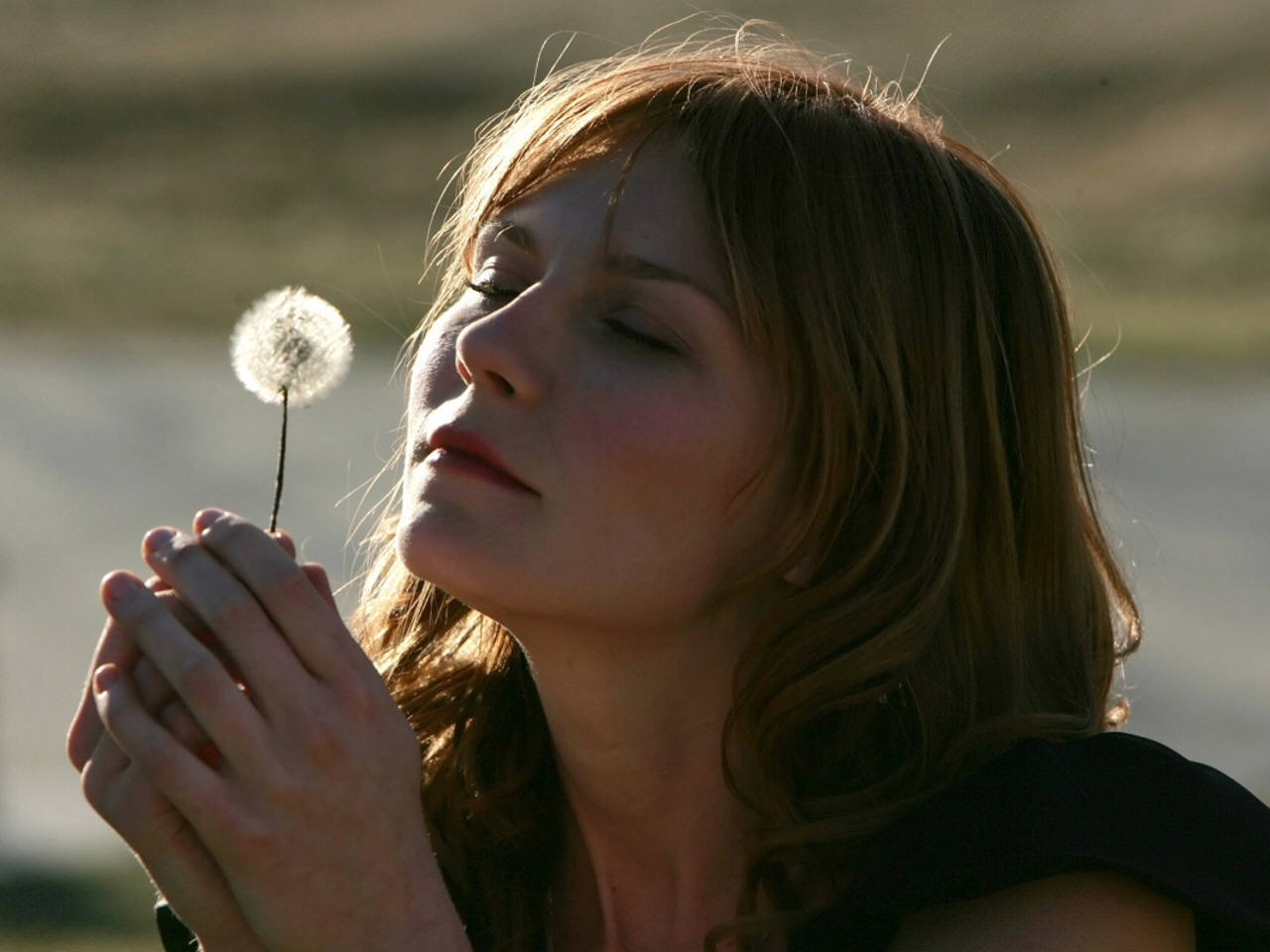 Kirsten Dunst holding a dandelion HD Wallpaper